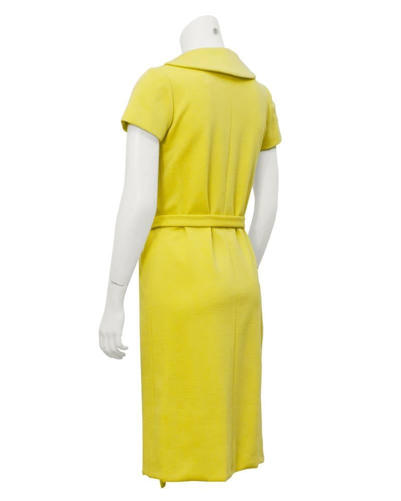 Butter yellow 1960's wool jersey Norell day dress with cream over sized buttons up the left side. Peter Pan collar and removeable belt are classic features of Norell design. Soft A-line silhouette, fully lined, excellent condition. Fits like a US