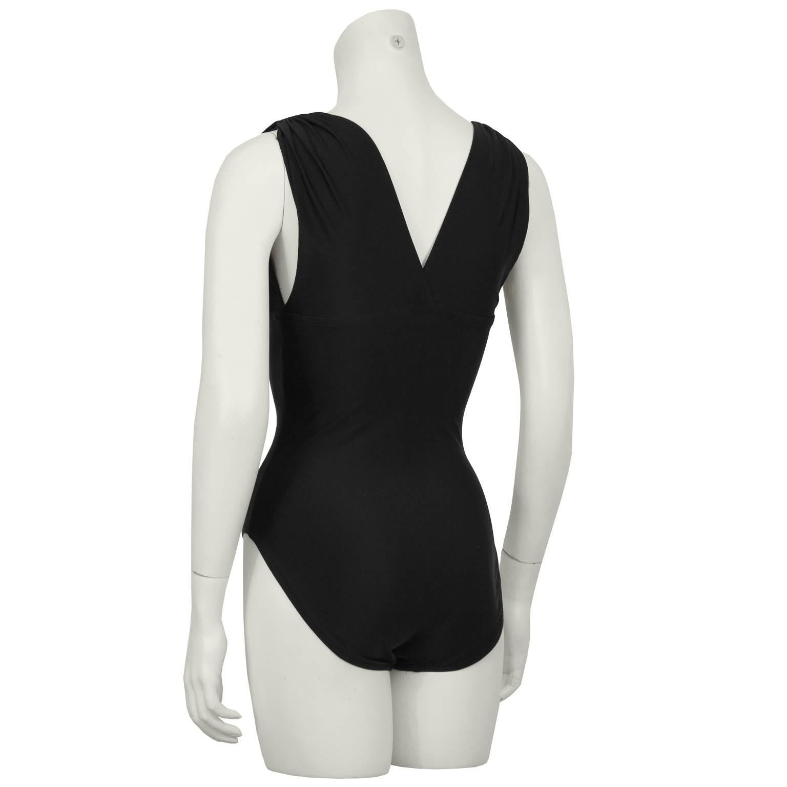 Elegant Bill Blass one piece black bathing suit from the 1980's. The Lycra spandex and nylon blend bathing suit has a flattering V neckline in the back and the front that extends up to the wide gathered shoulder. In excellent condition. Fits like a
