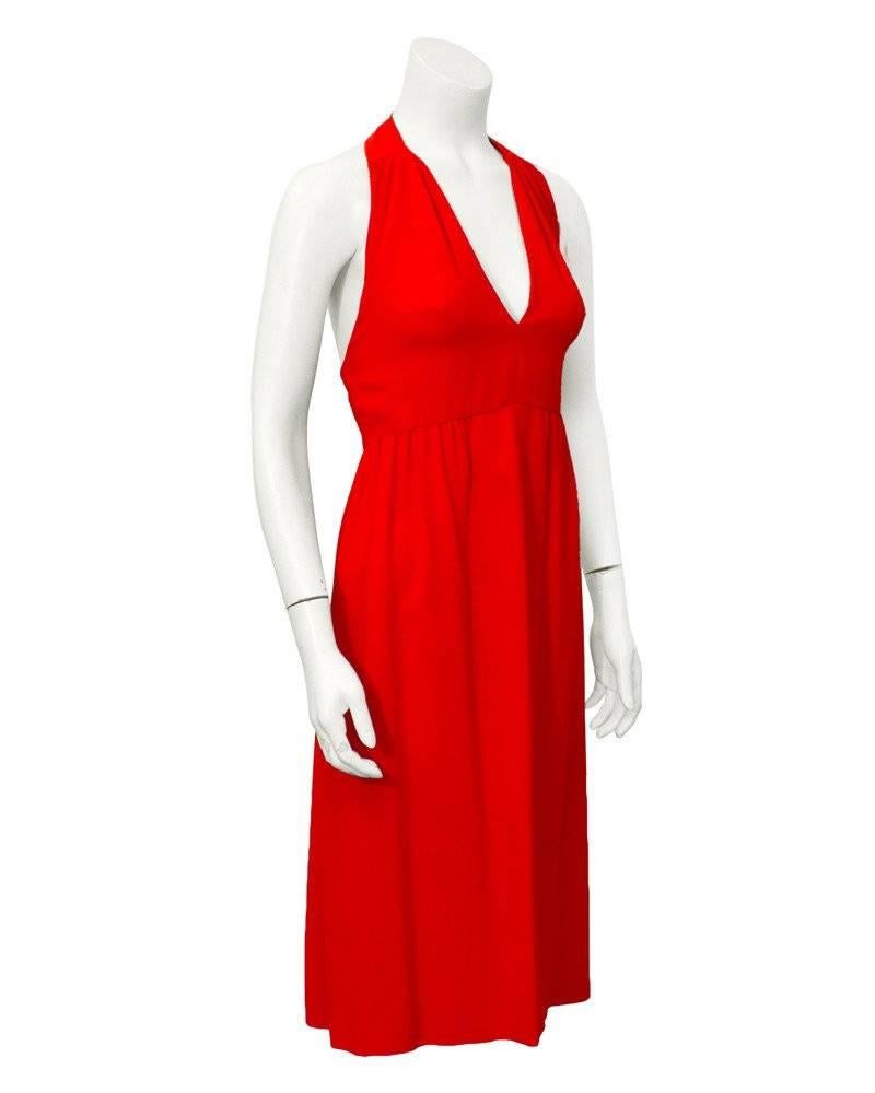 Fire engine red 1970's Malcolm Starr silk halter dress. Empire waist, knee length, with an open back. This dress is sophisticated and sexy. Neck fastens with snaps and back fastens with an invisible zipper. Great cocktail alternative to an LBD.