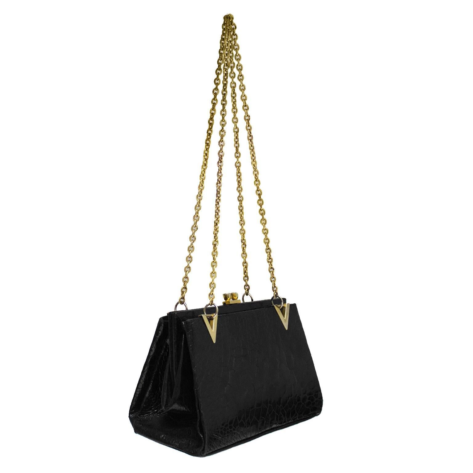 Beautiful 1960's Italian farm raised black skin shoulder bag with gold chain shoulder straps and V shaped detailed hardware. The expandable bag features two open exterior pockets and one hinge closure interior pocket. Zipper and open pocket