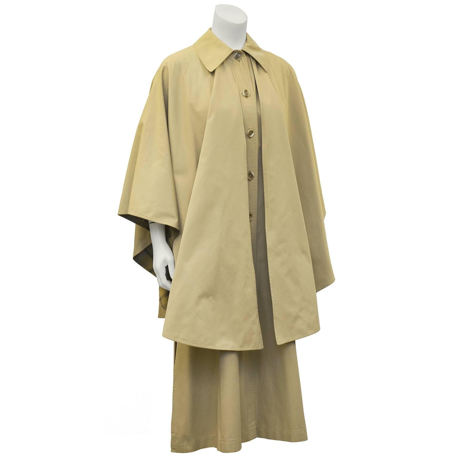 1970's Yves Saint Laurent khaki cotton poplin all weather cape lined in plaid light weight fabric. The cape silhouette was brought back into mainstream fashion in the 1970's as Yves Saint Laurent explored styles that had grace and versatility for