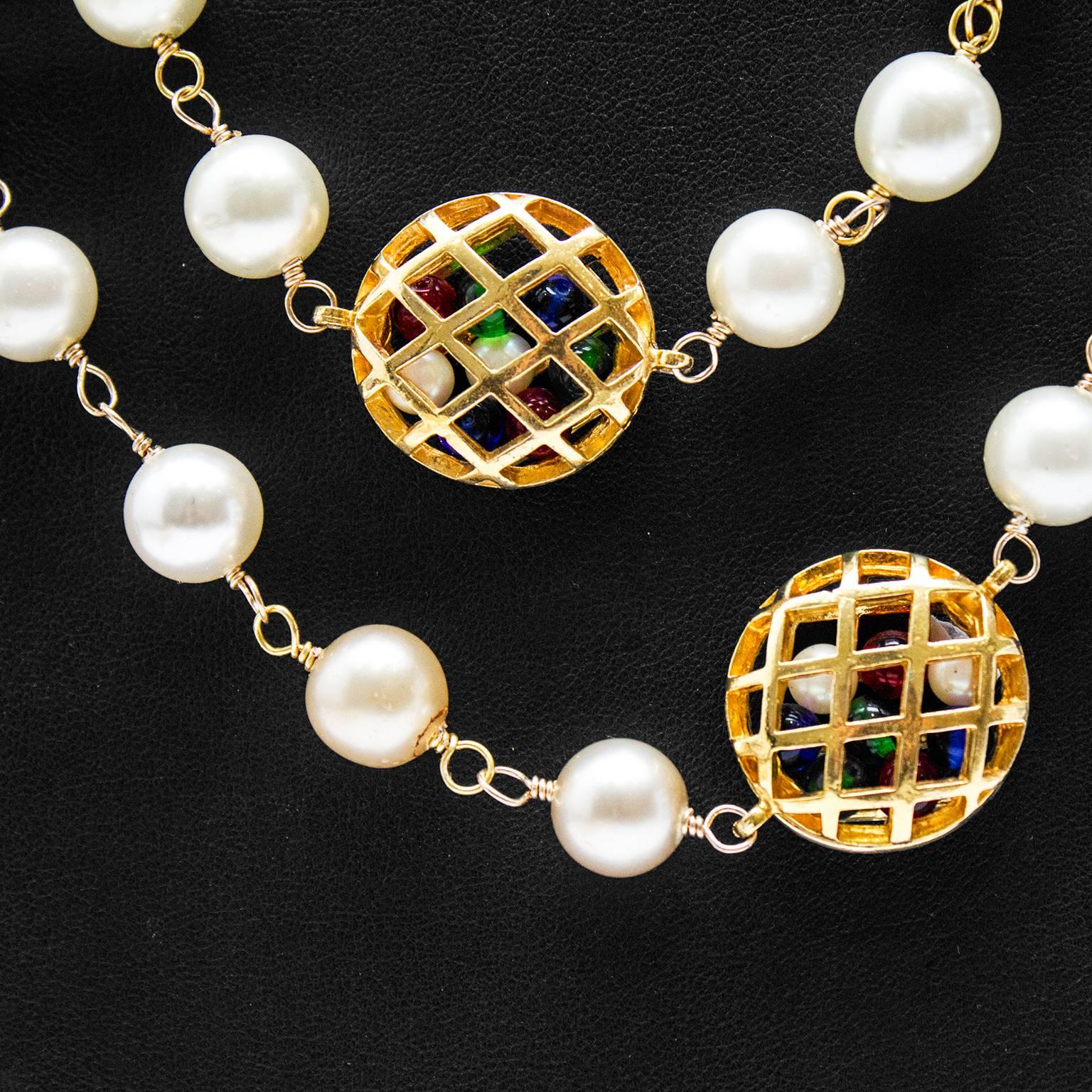 Excellent1980's Chanel necklace featuring pearls and hollow basket weave gold cages filled with green, blue and red poured glass beads. Can be worn long or wrapped around neck. Chanel markings on inside of cage near clasp, in excellent condition.