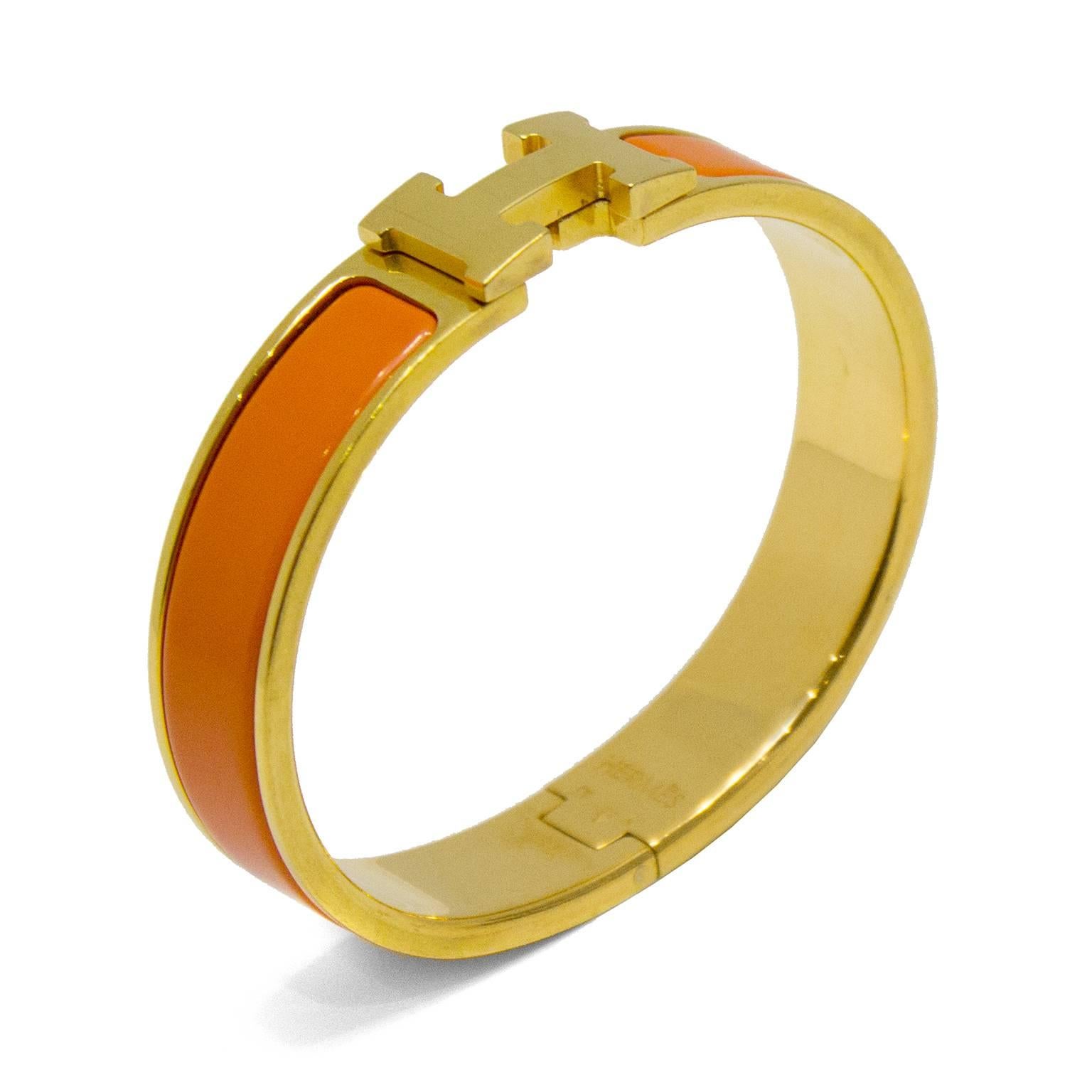18K yellow gold-plated Hermès narrow Clic Clac H bracelet featuring bright orange enamel inlay with H turn lock closure. Stamped K from 2007. Excluding box and pouch. Fits a wrist size of 6.25