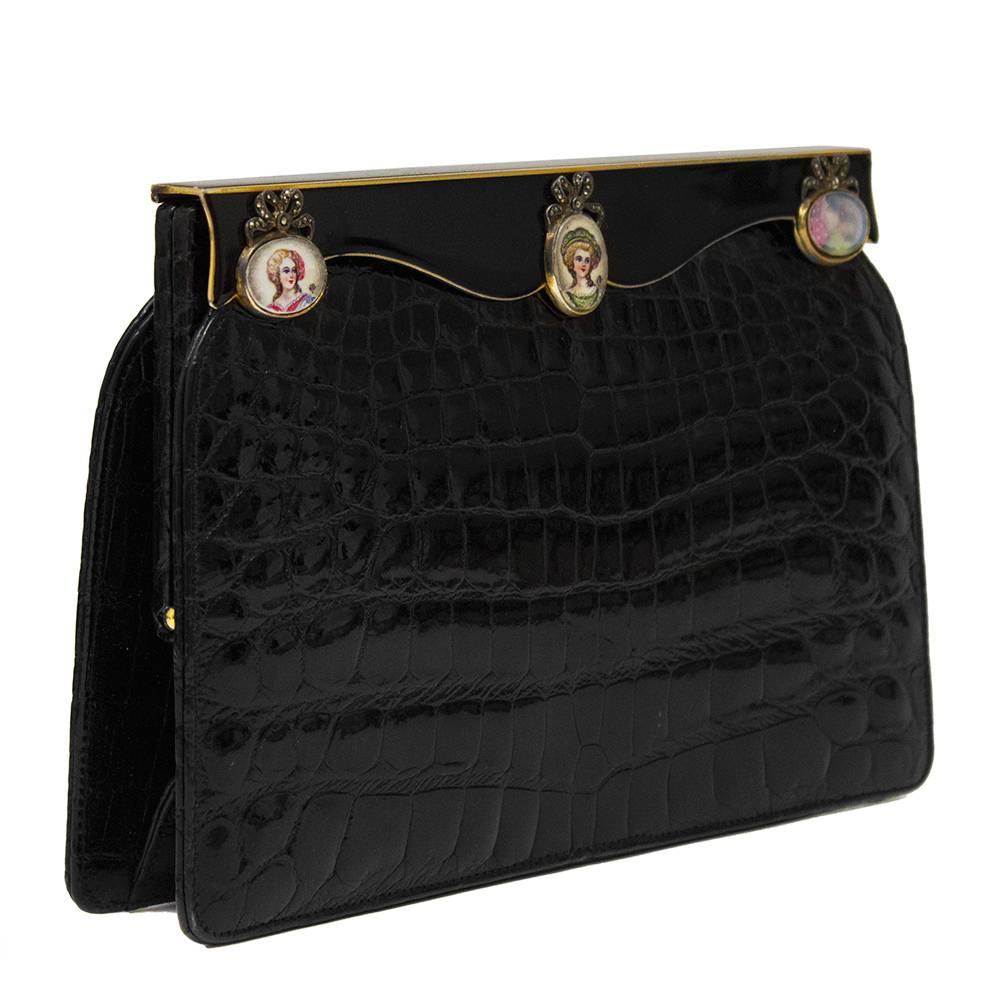 Elegant black croc embossed clutch dating from the 1950's. 3 hand painted cameo details on french enamel clasp, embellished with beautiful bow details embellished little crystals. Gold accents on hardware. Clean interior. Excellent vintage