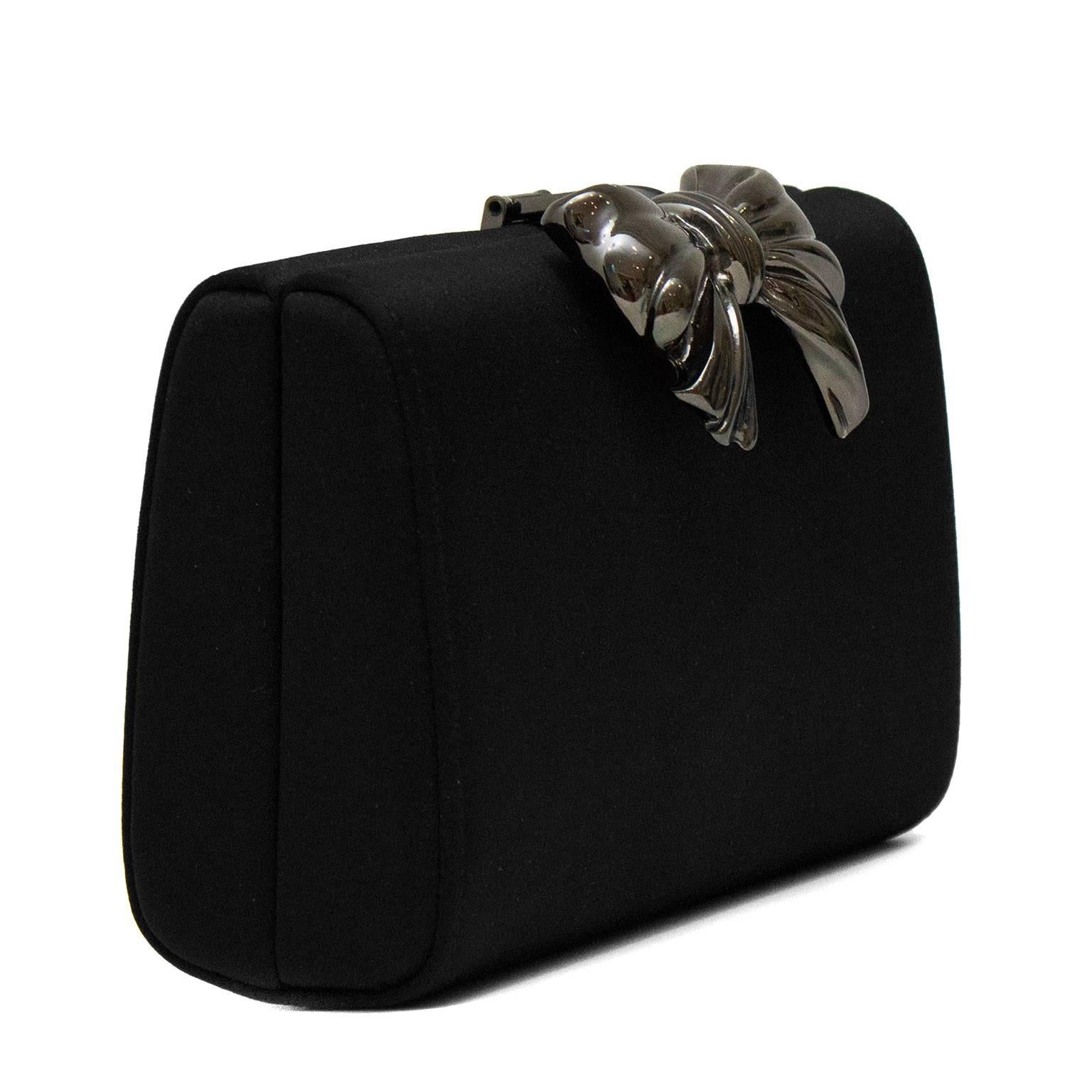 Red carpet ready stunning black satin clutch by Italian designer, Rodo. Silver metal bow detail at clasp. Clean interior with Rodo logo lining. Hidden 23
