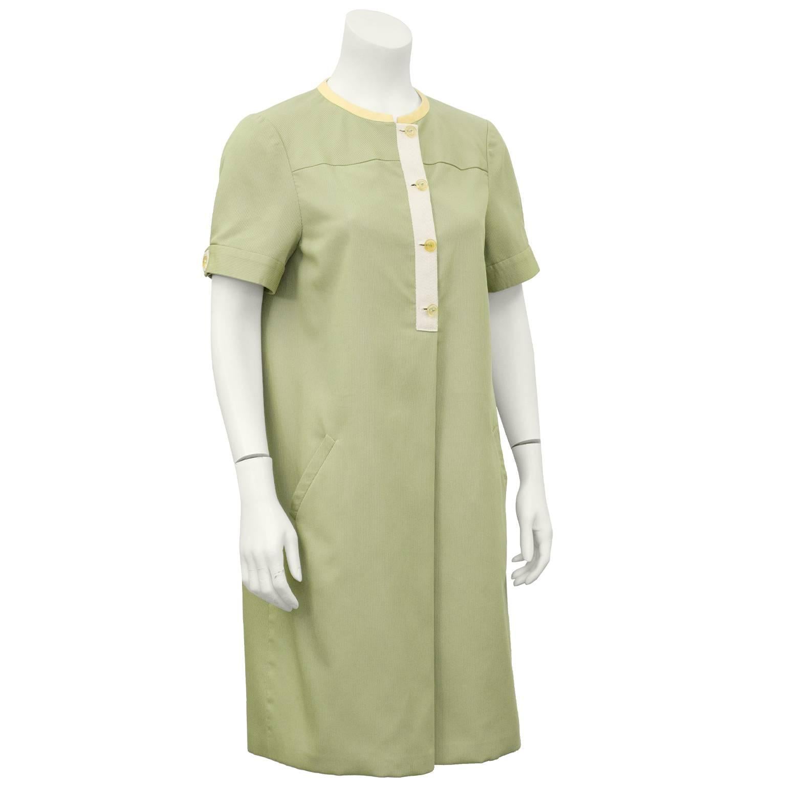 1980's Geoffrey Beene day dress in a sage green ribbed silk. Contrasting butter yellow linen trim around neckline. Ribbing in fabric at yoke is diagonal, while rest of dress is vertical. One inverted pleat and pockets. Lined in adorable butter
