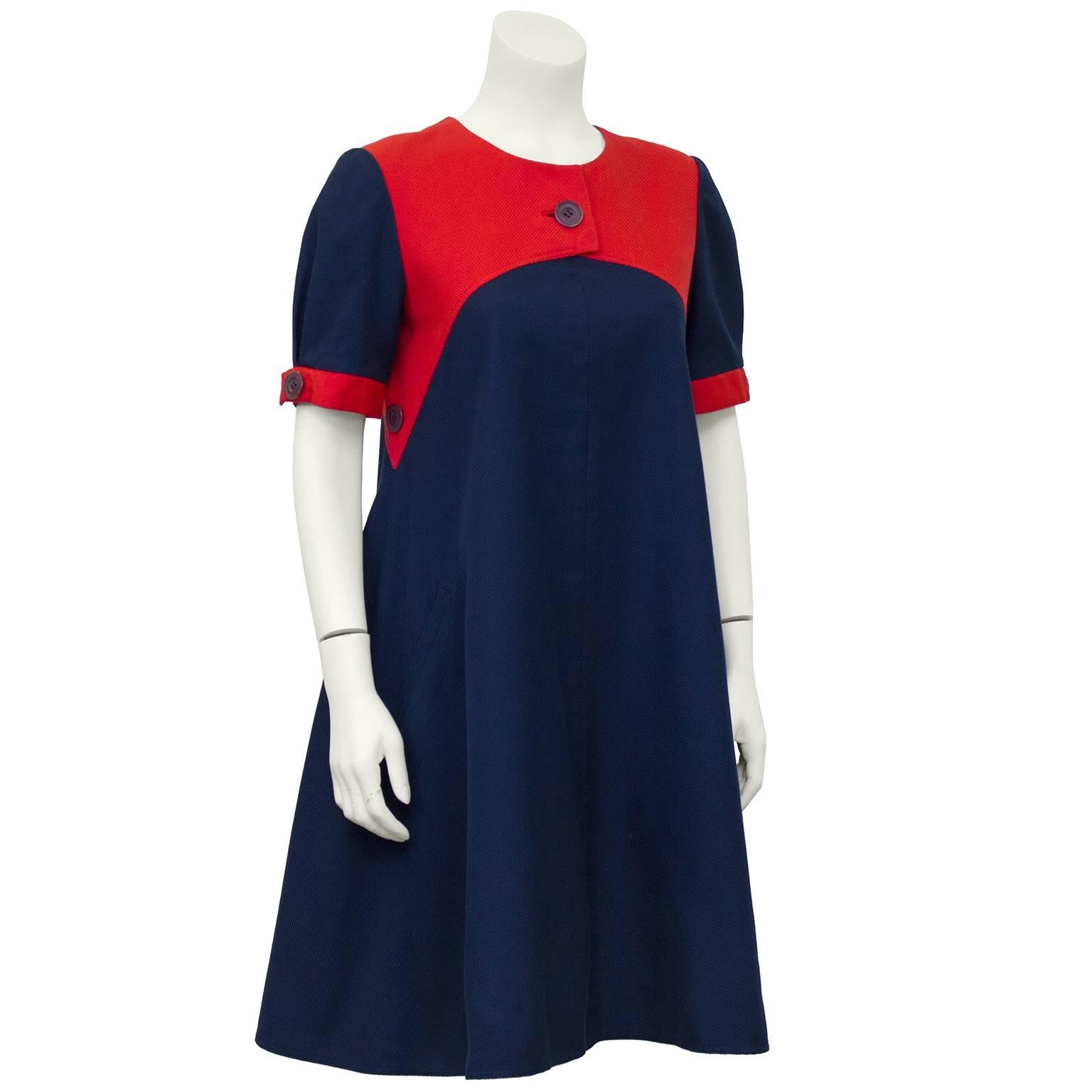 1980's Geoffrey Beene navy blue weaved cotton swing dress with contrasting fire engine red yoke and sleeve trim. Eggplant plastic button details at center of yoke, sleeves and side seams. Lined in navy silk with a 4