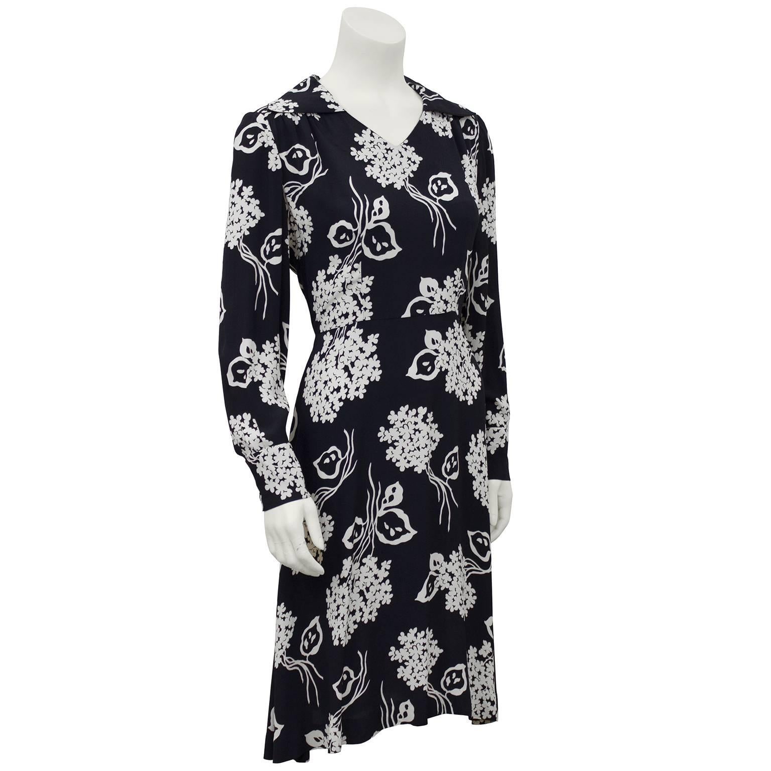 Vestido de rayón con estampado floral negro y crema de los años 40. Pequeño cuello en V femenino con cuello y mangas largas. Muy ponible hoy con unas zapatillas blancas. Bonito tejido, excelente estado vintage. Muy en tendencia lady-like para la