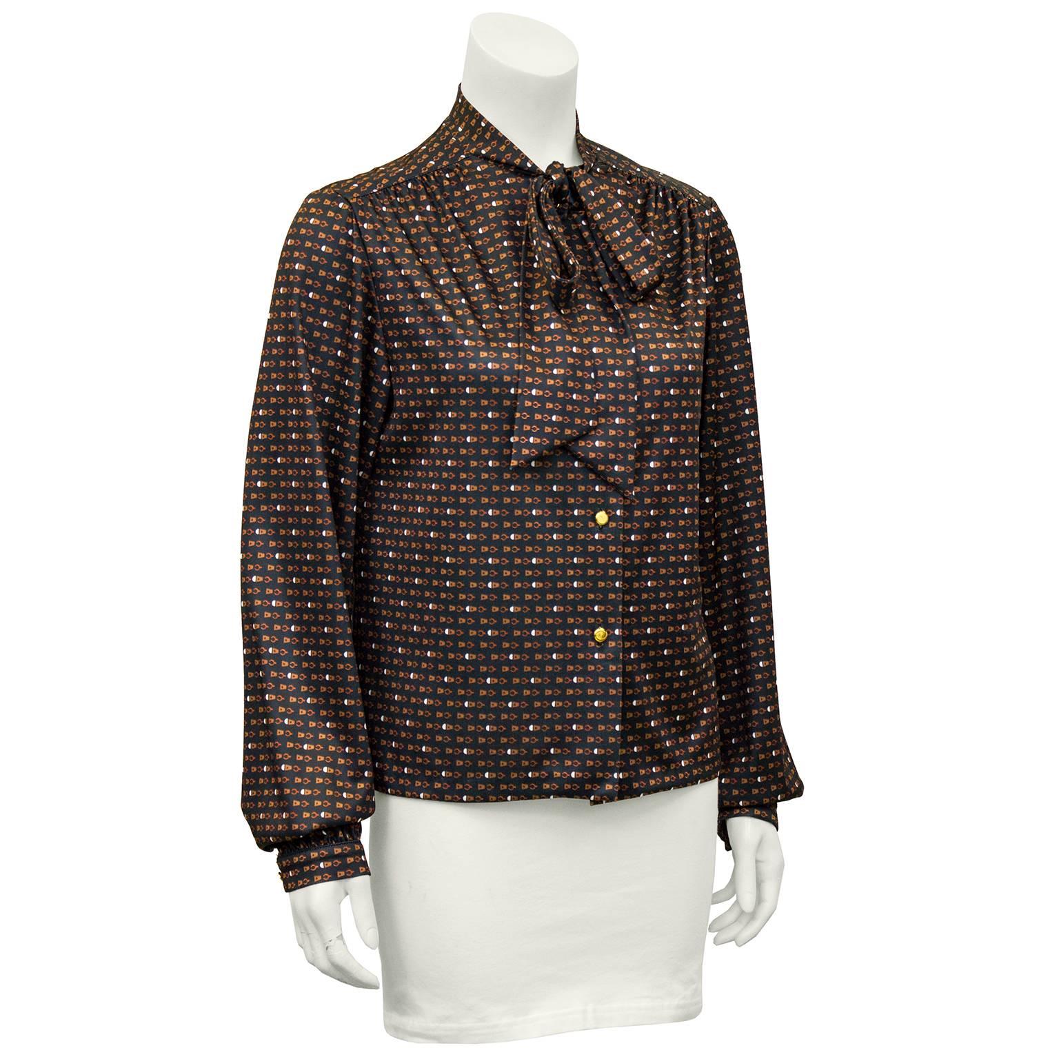 1970's polyester Pering blouse featuring a pussy bow detail at the neck. Black with a brown all over print. Gold buttons. Fits like a US size 6, excellent vintage condition. 

Sleeve 21" Shoulder 22" Bust 38" Waist 38" Hips