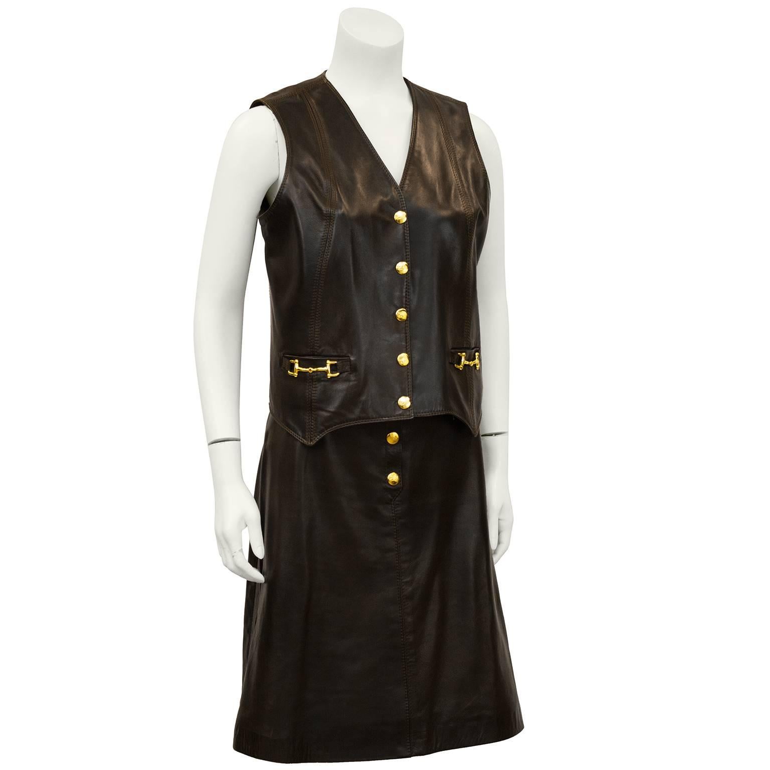 1970's Celine brown leather vest and skirt ensemble. Accented with gold hardware snaps and decorative horse bits on vest pockets. Vest would be wonderful with jeans and the skirt has a great shape that works with a variety of tops. Very versatile