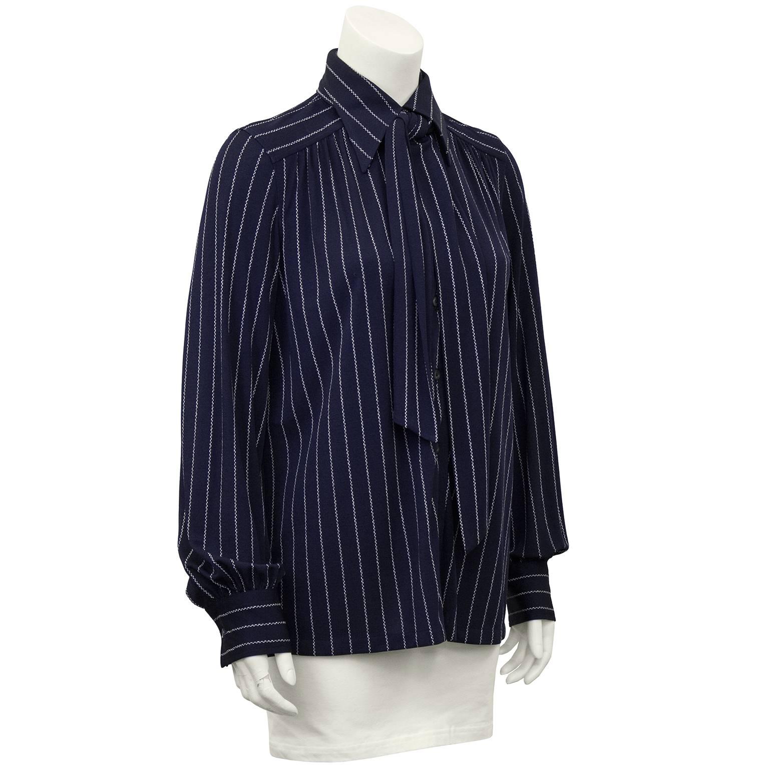 Late 1970's navy blue and white pin stripe silk blouse. Exaggerated collar, bishop sleeves and optional neck tie that can be styled to your liking. Excellent vintage condition. Fits like a US 8. 

Sleeve 21