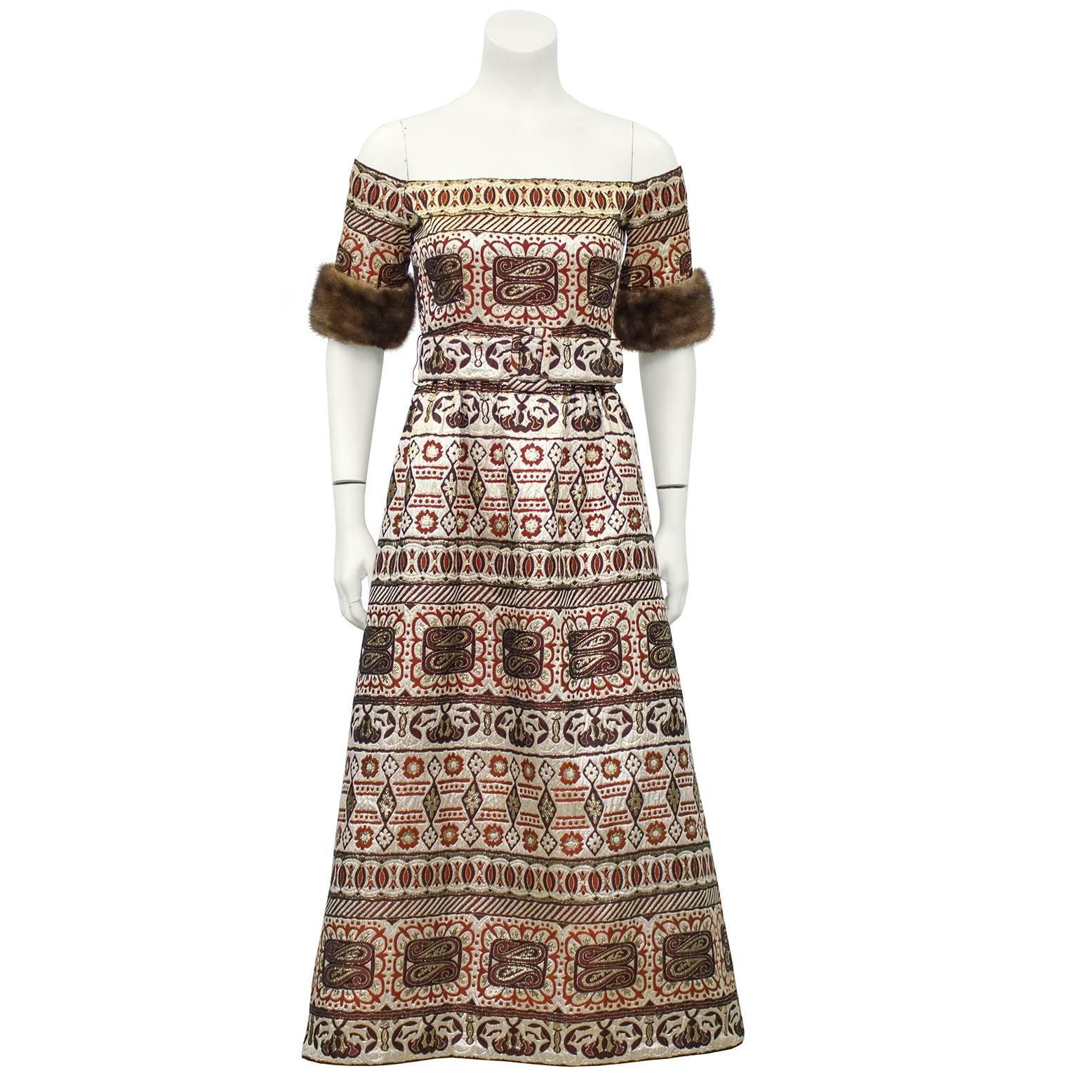 Opulent and beautiful Oscar de la Renta gown dating from the 1970s. Intricate brocade with tones of champagne, gold, brown and rust orange. Off the shoulders neck line, with short sleeves trimmed in brown mink. Matching adjustable empire height