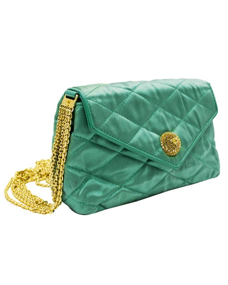 1980s Emerald green satin quilted Chanel evening bag. The soft silk bag is stitch quilted with a top flap and the CC logo stitched on the underside. The six strand gold chain strap is secured to the bag with matching emerald green leather tabs and