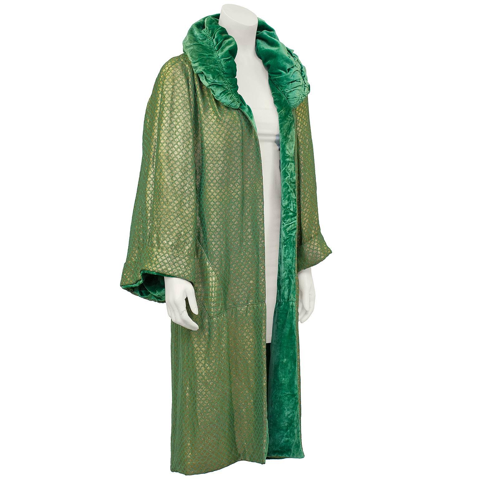 Stunning opera coat dating from the Roaring 20s. Gorgeous gold and green silk jacquard lined in emerald green velvet. Large ruched green velvet collar. Beautiful draping. Excellent vintage condition. Generous fit from US 2-8. No damage or visible