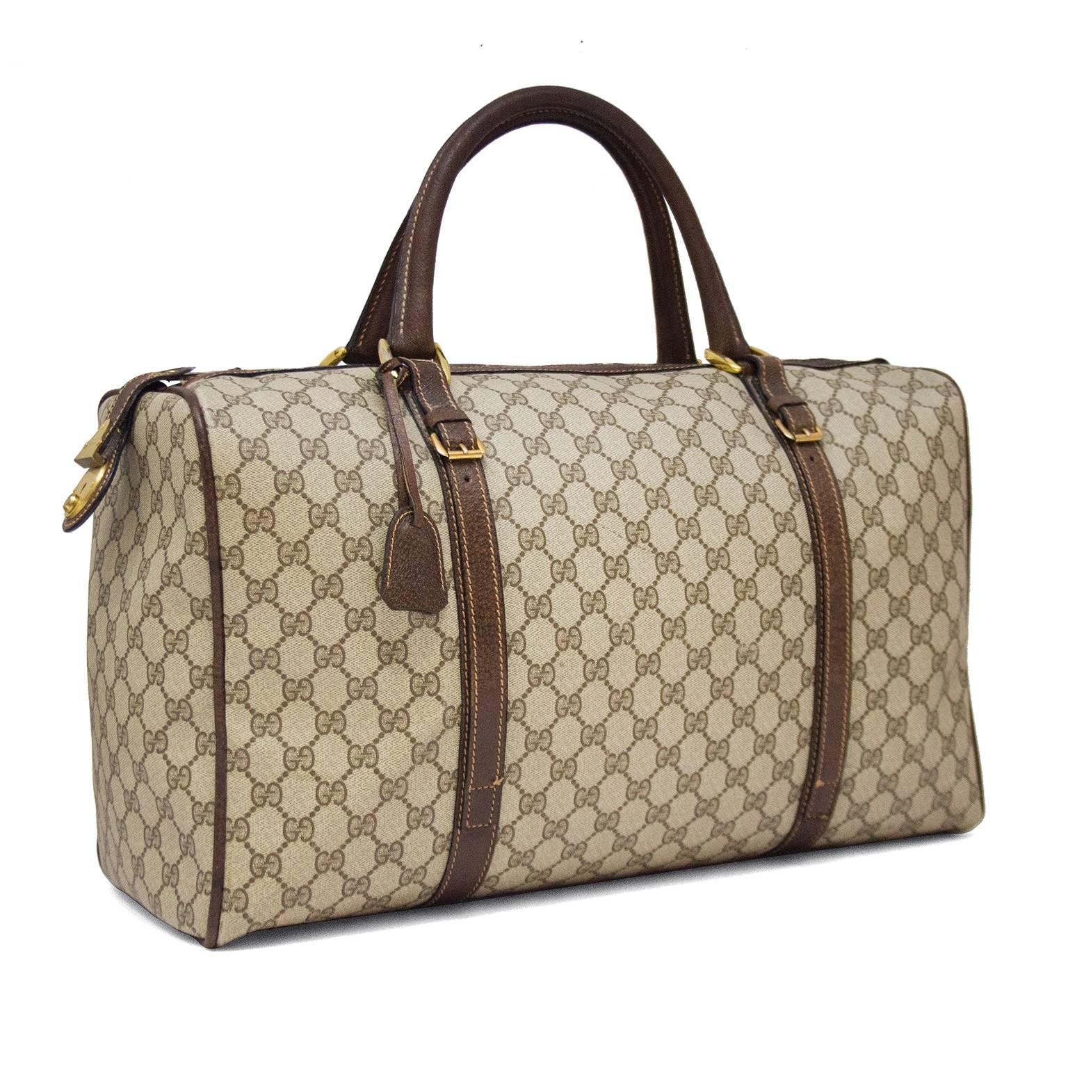 Die perfekte Fluchttasche! 1970er Gucci Monogramm Vinyl Weekender Duffle Bag mit braunem Lederbesatz und goldfarbener Hardware. Die Reißverschlusslasche rastet in ein großes goldenes Schloss an der Seite der Tasche ein. Sehr sauberer Innenraum ohne