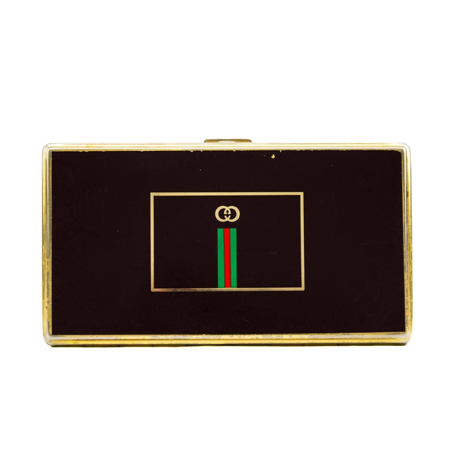 1970s Gucci rectangle business card case. Brown faux enamel finish with gold trim and gold interior. Gucci logo at centre with classic Gucci green and red stripe. Good vintage condition, slight scuffing throughout. Unique early Gucci accessory.