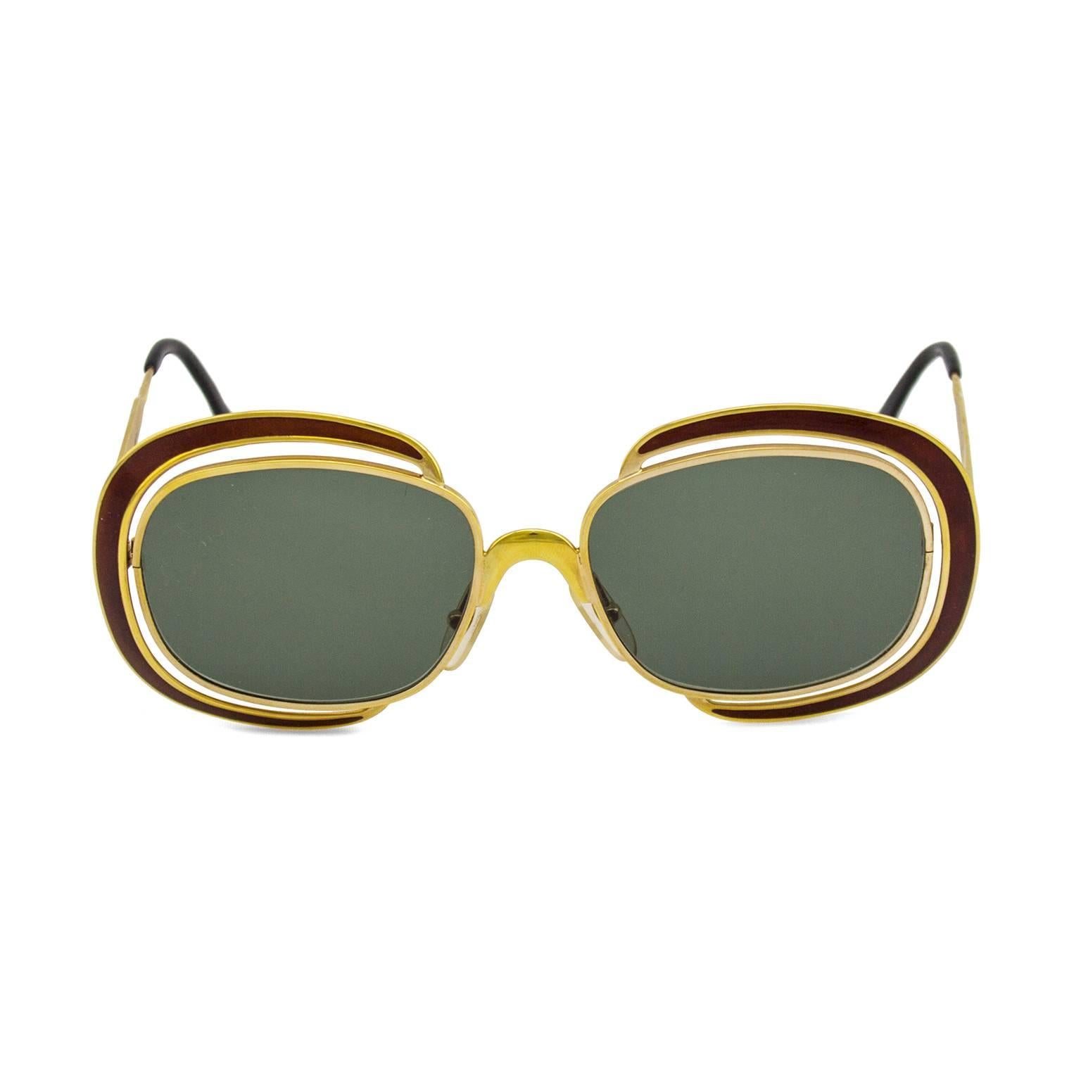 Christian Dior oversized sunglasses dating from the 1960's. Gold tone metal and maroon hardware with cut outs. Gold CD logo on arms and brand engraving on arms interior. Excellent vintage condition, new grey lenses. No case or box. Oversized and