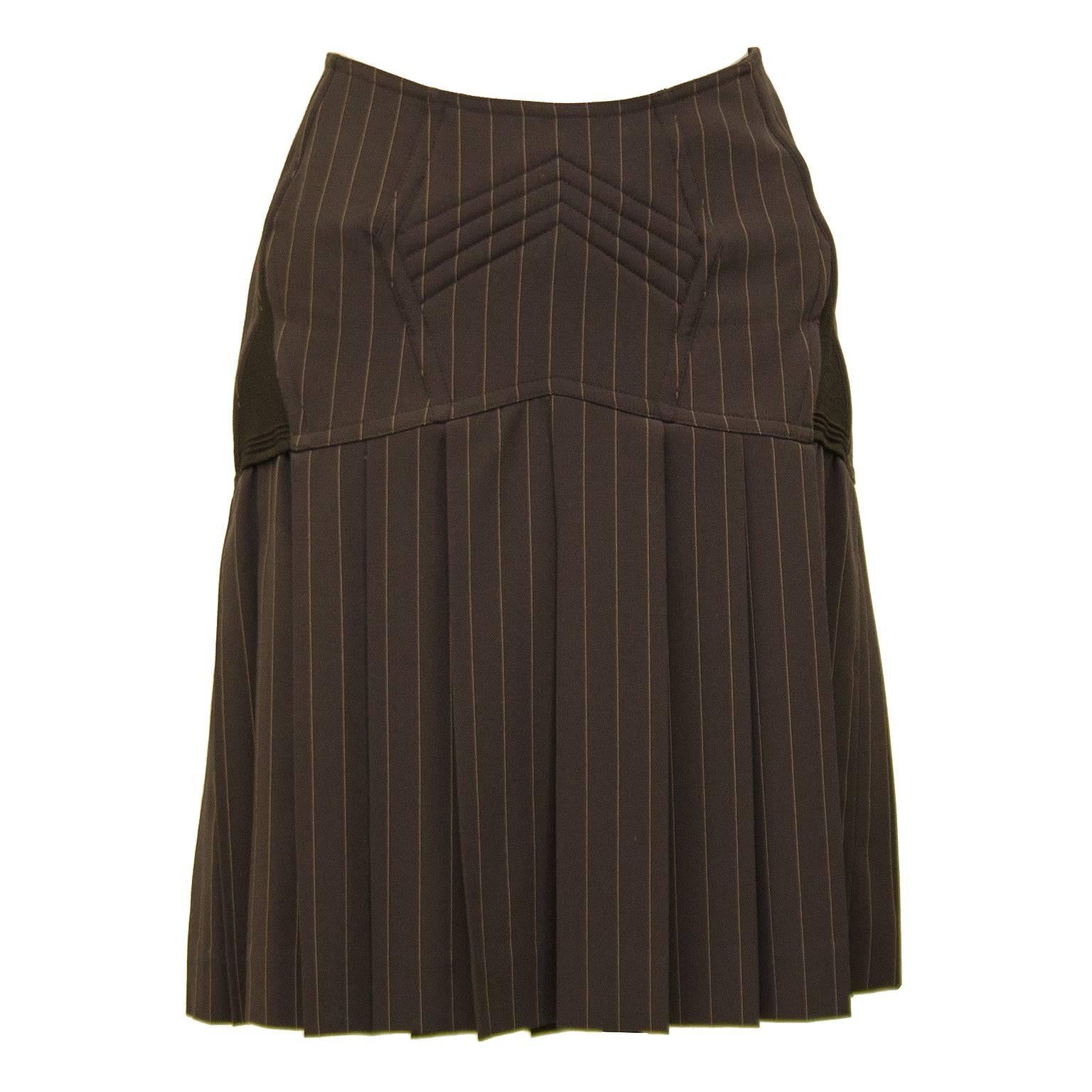 1990s Jean Paul Gaultier brown on brown pin stripe mini skirt. Drop waist with boning at butt, corset lacing up the back and pleated skirt. Chevron stitching details at front and elastic darts at side seams. Silver metal zipper closure. Brown silk