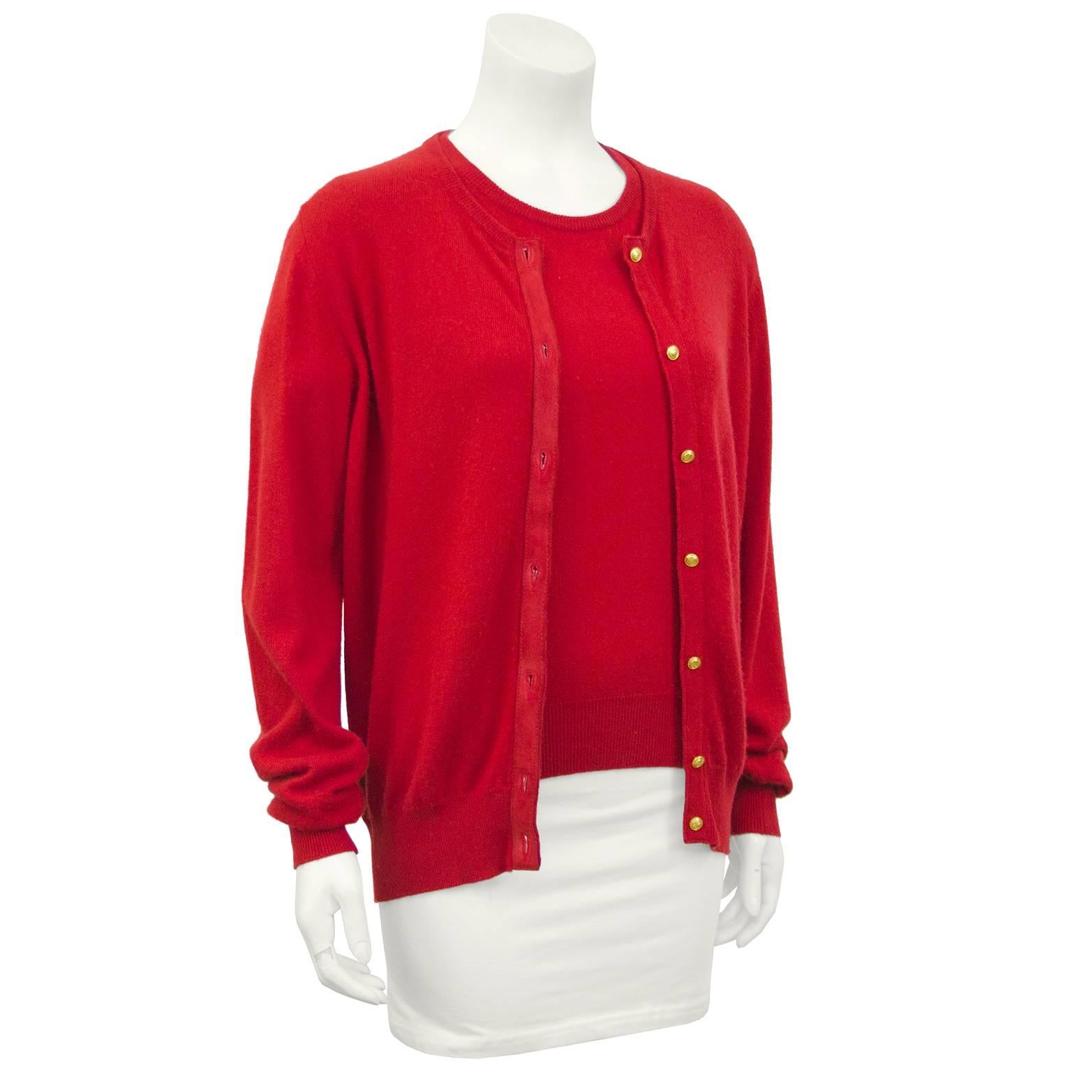 Early 1990s Gucci red cashmere twin set. Cardigan with a monochromatic red suede trim and small gold Gucci logo buttons. Matching short sleeve top. Can be worn together or separately. Both taper at hips with ribbed waistband. Gorgeous Italian