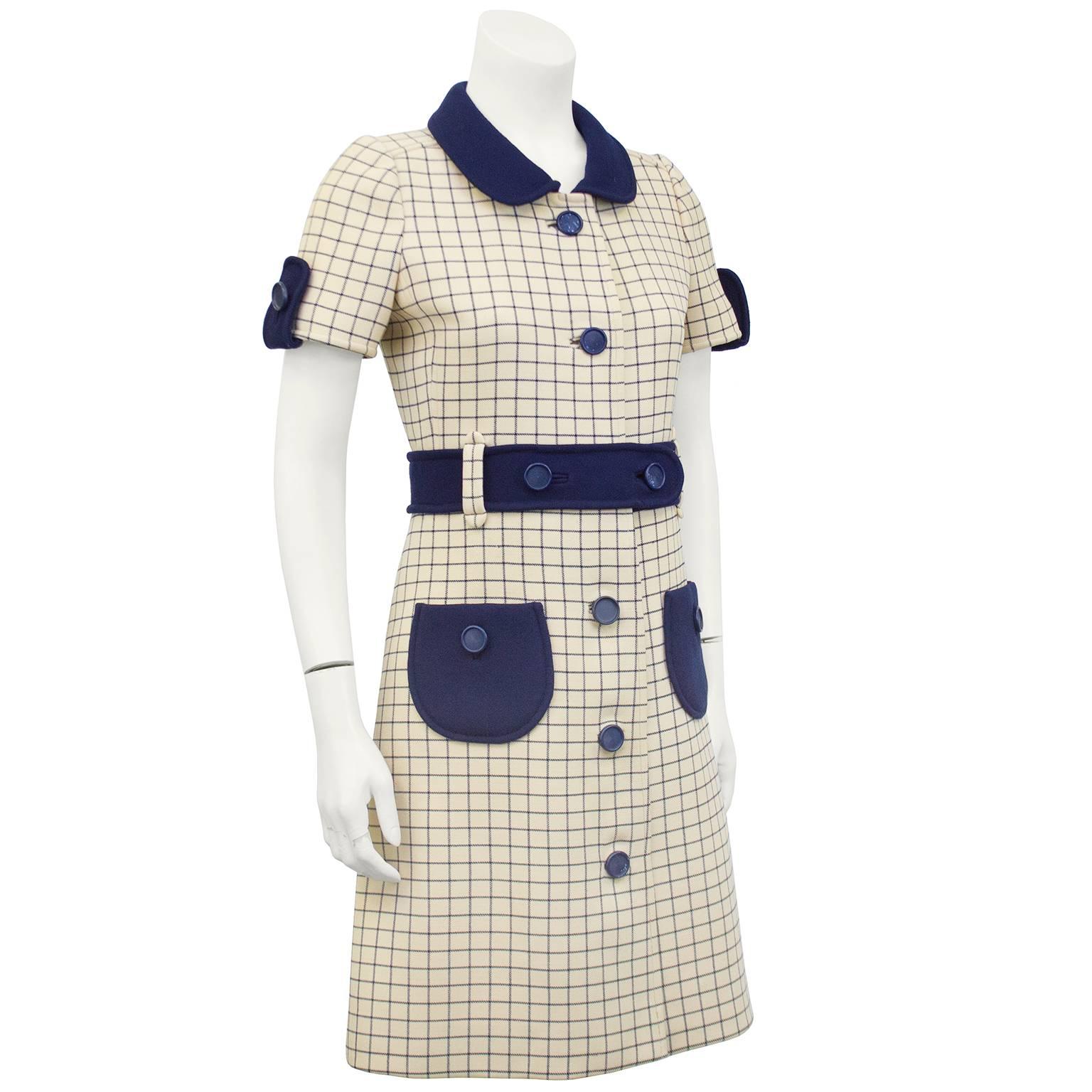 1960s chic mod Courreges day dress. Cream with thin navy blue window pane check. Navy blue peter pan collar, epaulets on the sleeve, buttons, waist belt and patch pockets. Cream silk lining. Excellent vintage condition. Fits like a US 2. 

Sleeve