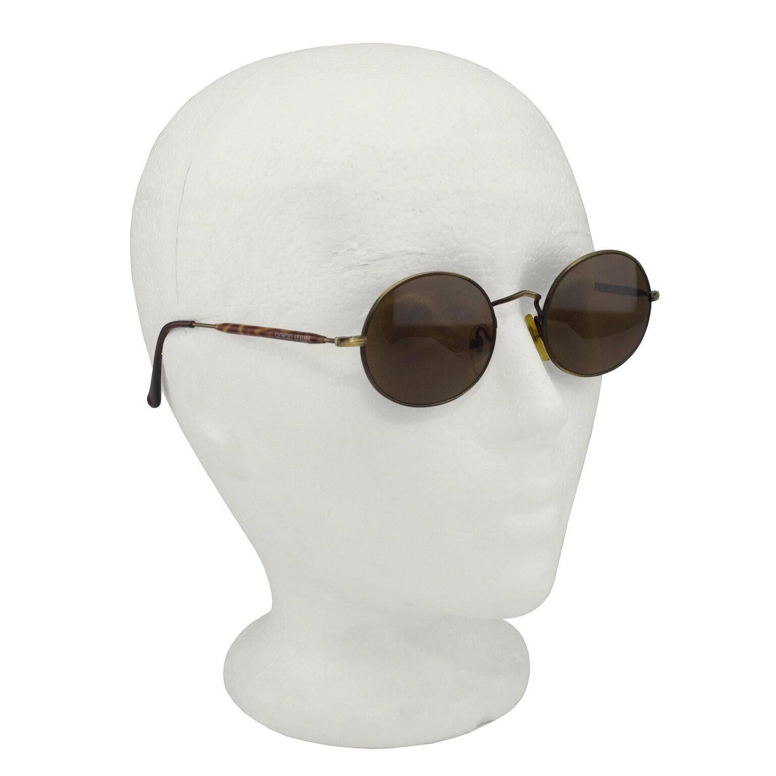 Giorgio Armani brown round sunglasses from the early 1990s. Golden brown wire frames with brown lenses and a small GA logo stamped on outer corner of each lens. Tortoise shell detail on the arms with branding stamped on inside of arms. Very on trend