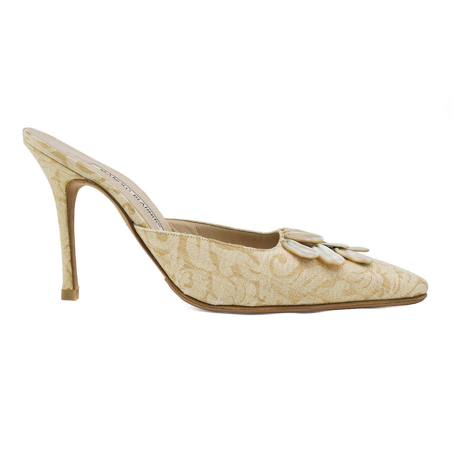 1990s classic Manolo Blahnik heeled mules with a twist. Cream brocade with mother of pearl bead details at toe box. Excellent vintage condition. Very minor wear to interior, exterior as been resoled. Very Carrie Bradshaw. Size 38.5. No box.  