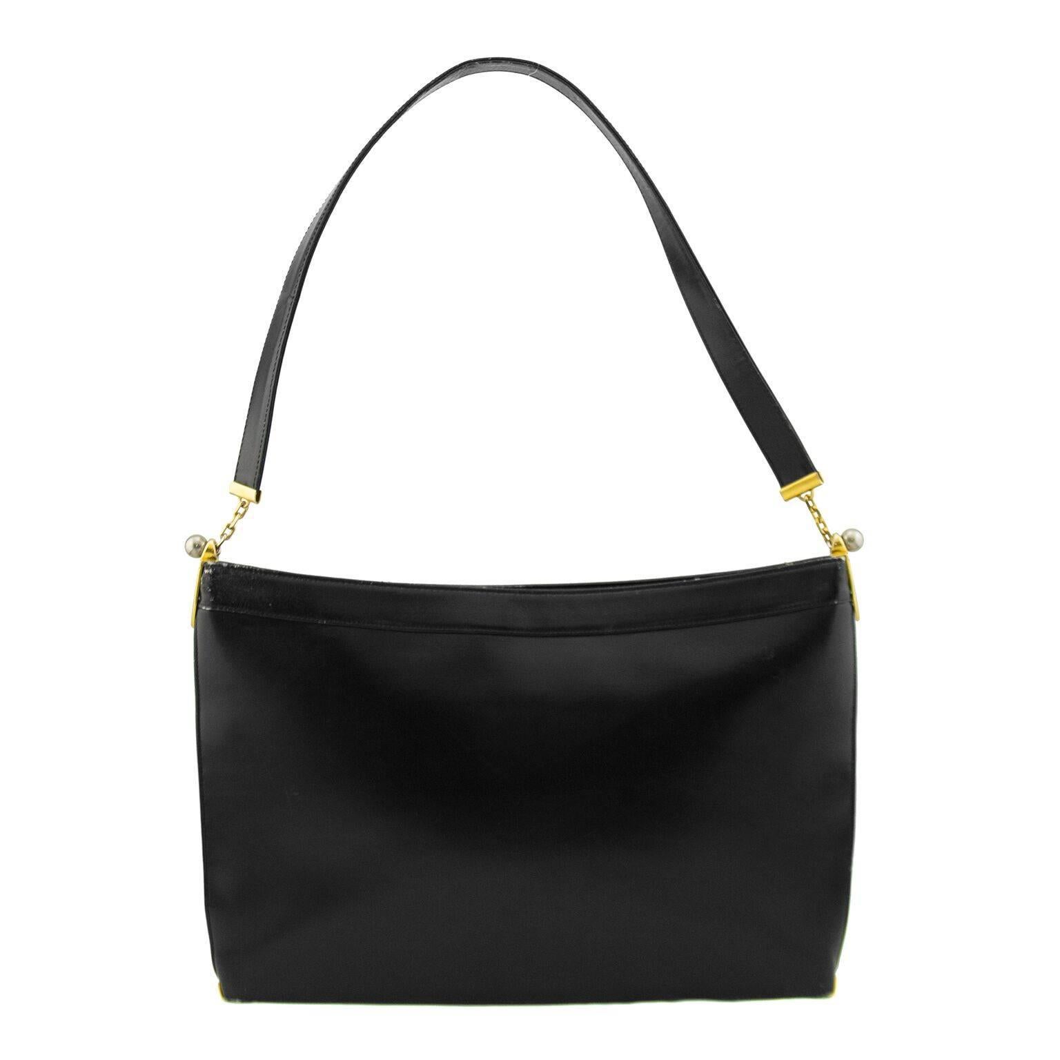 Black calfskin large rectangle handbag dating from the 1960s. Contrasting gold and silver hardware with a large CD logo in the centre. Black leather interior with gold brand stamp and one side slit pocket with gold lining. Good vintage condition,