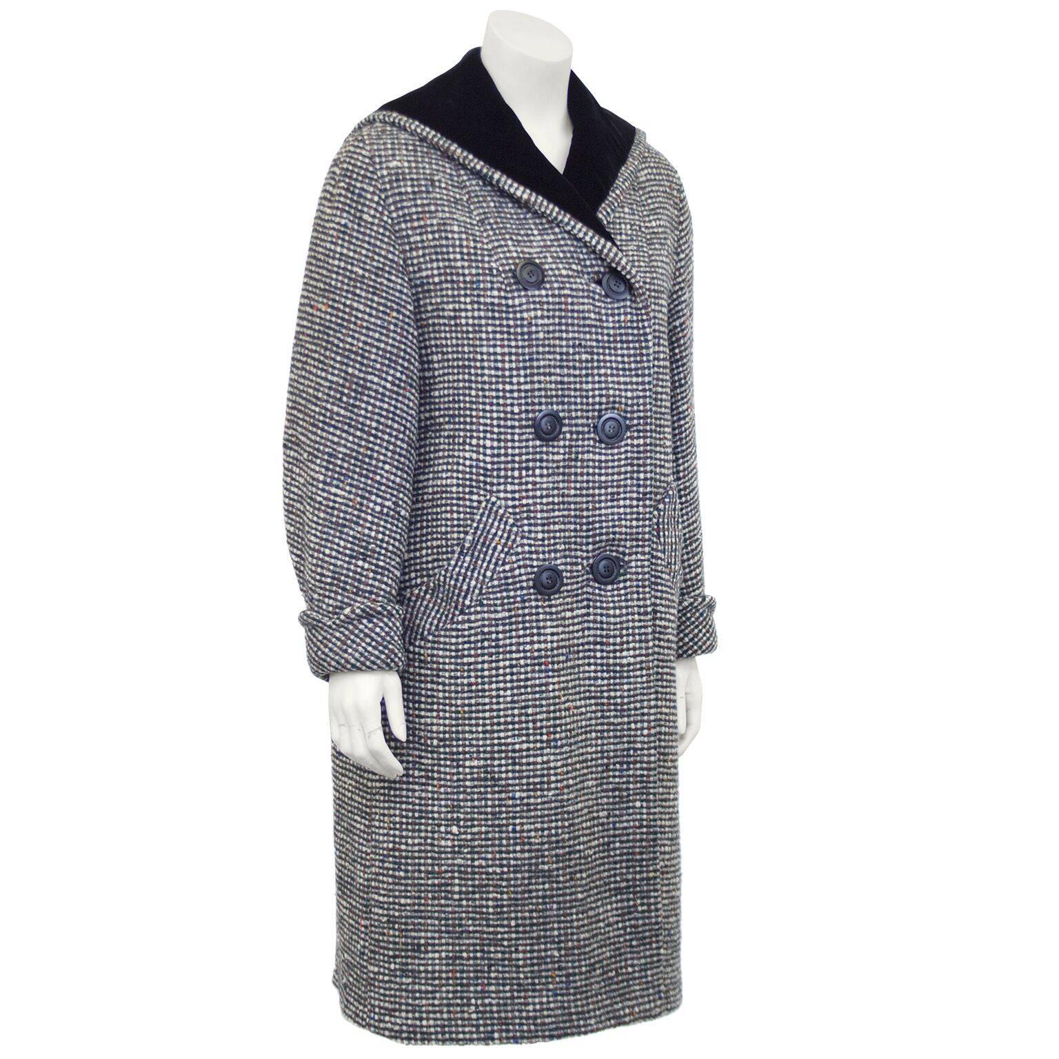 Amazing 1960s black and white wool tweed long coat with specs of green, brown, blue and yellow. Double breasted with large black plastic buttons. Black velvet collar with a cut out chevron detail at back. Excellent vintage condition. Fits like a US