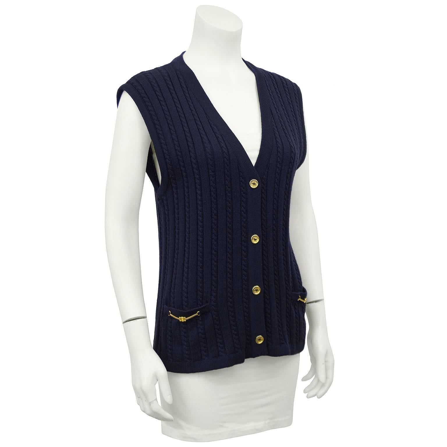 Céline Sport cable knit navy blue vest dating from the early 1970s. Small gold buttons down centre and the iconic Céline gold chain logo details on patch pockets. Excellent vintage condition. Fits like a US 4/6. 

Bust 35” Waist 33” Hips 37” Length