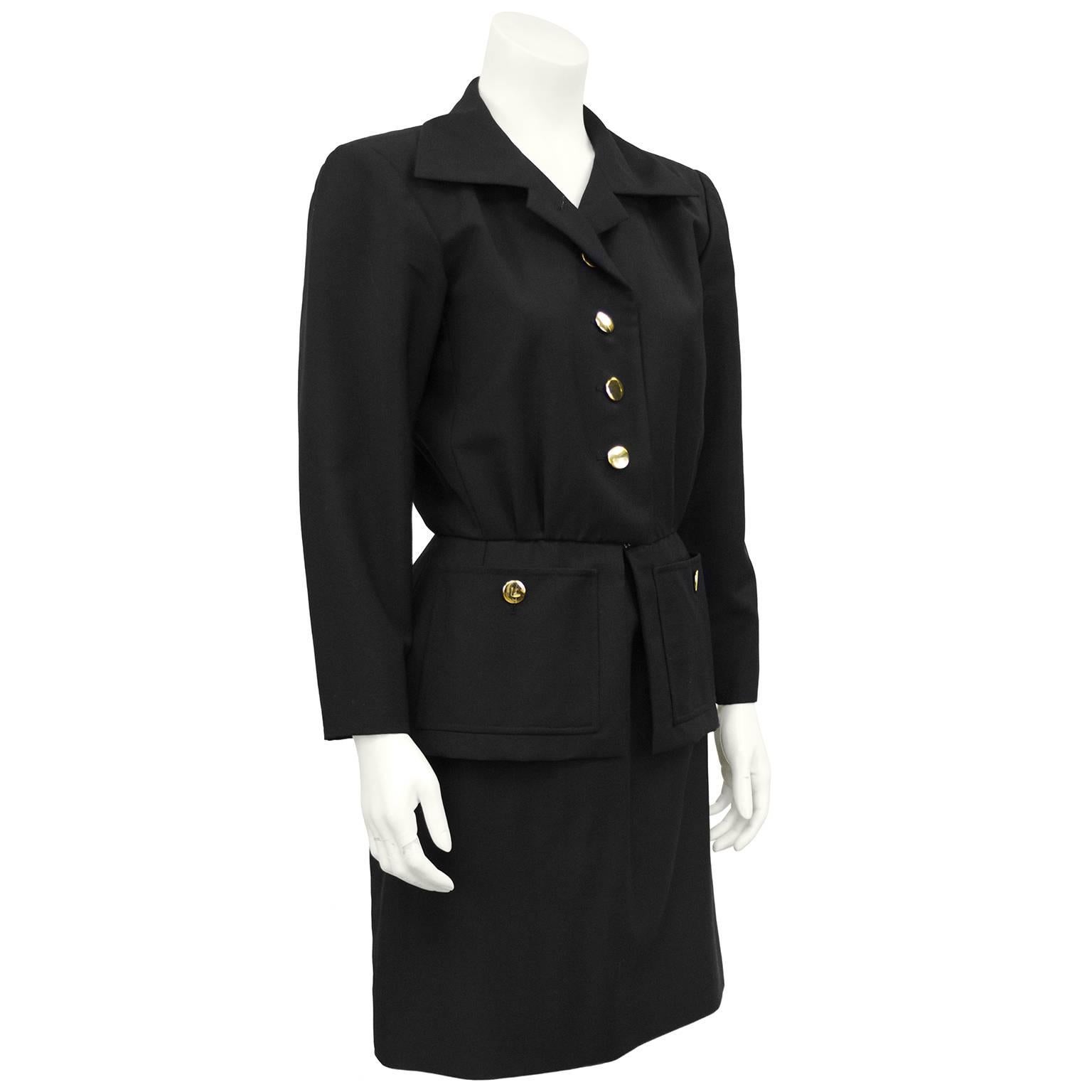YSL/Yves Saint Laurent black wool gabardine skirt suit from the 1980s. Wide lapel has a small notch and the jacket has gold disc buttons down the front and a hidden flat hook at the waist. Fitted at the natural waist and finished with a slight