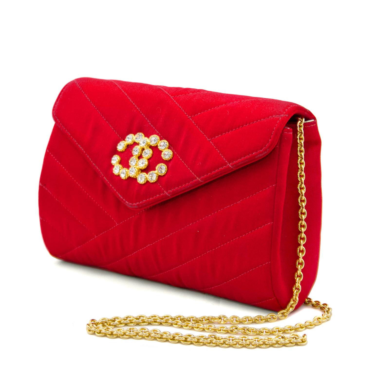 Bright red satin Chanel evening bag from the late 1980s. Diagonal line quilting covers the whole purse and the pointed top flap has a rhinestone CC on the front and closes with a hidden magnetic snap. Interior is in immaculate condition, lined in