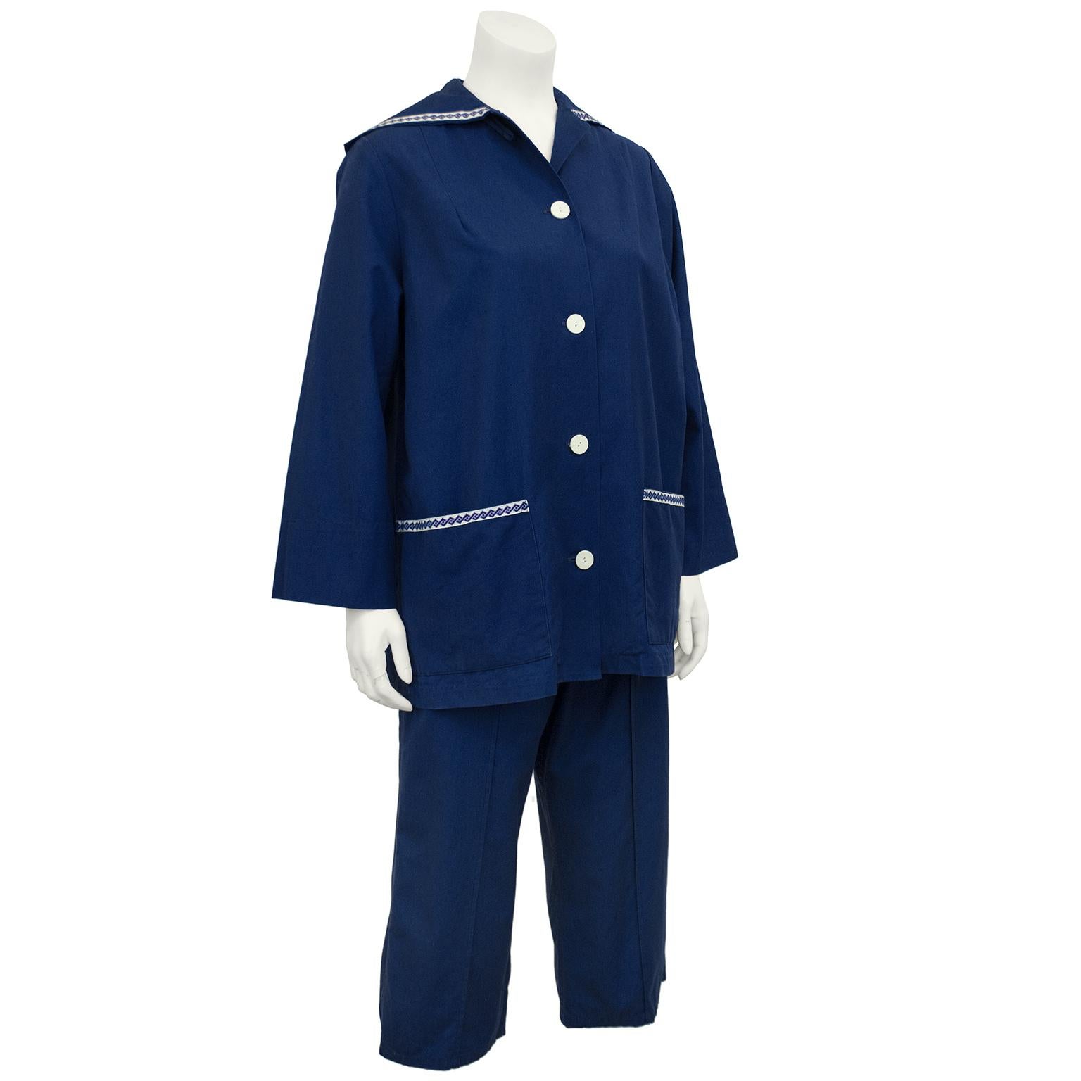 Adorable 1950s indigo cotton ensemble by the Portland, Oregon based label White Stag. The boxy style jacket has a sailor collar, front pockets trimmed in white ribbon with blue square pattern detail and white buttons down the front. The high waisted