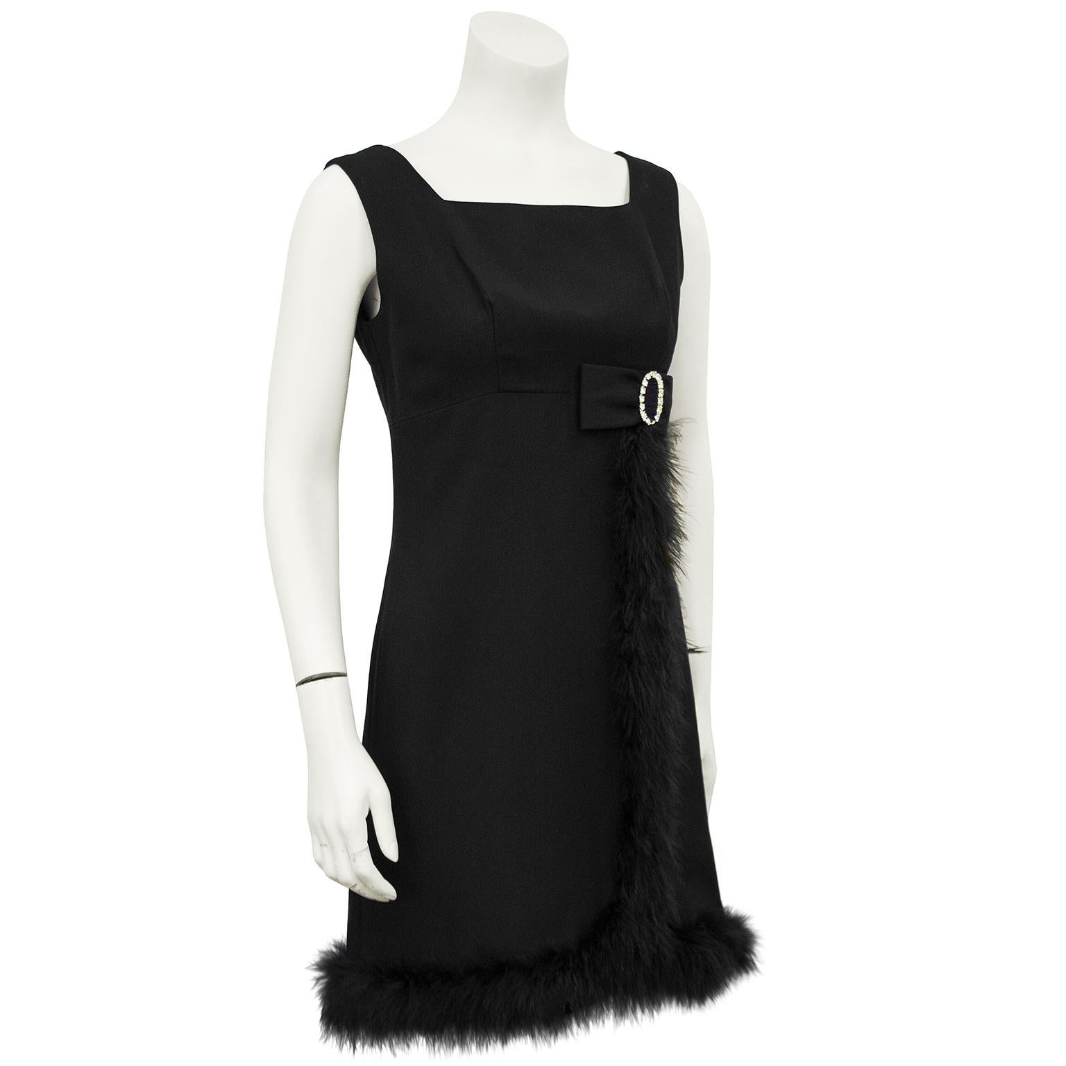 Adorable 1960s black cocktail dress with crystal buckled bow and marabou trim. The square neckline and empire waist will flatter any figure and the sweet details make this dress perfect for any occasion, any season. Zips up the back with darts at