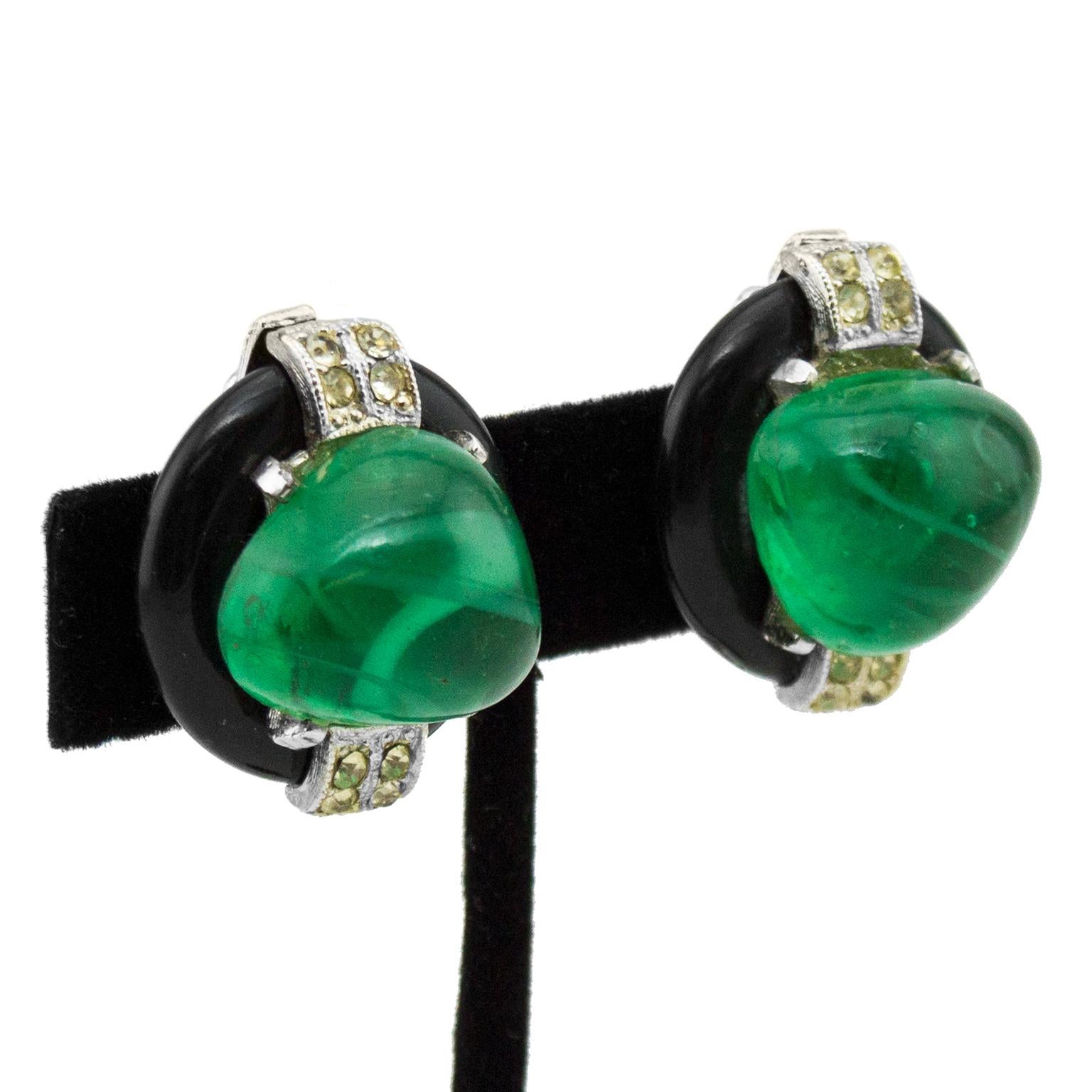Fabulous 1980s oval KJL faux emerald cabochon clip on style earrings. The irregularly shaped cabochons are surrounded by faux onyx and set in silver with rhinestone bands. In excellent condition, signed on the back.