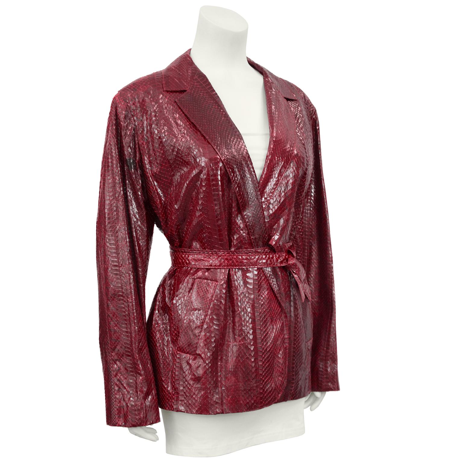Anonymous glossy snakeskin oversized blazer in deep bordeaux from the 1980s. The jacket has a notched lapel and side slit pockets on the hips. The jacket and pockets are lined in matching satin. Belt ties at waist, meant to be oversized. In