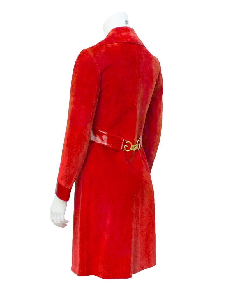 Fabulous 1970's red suede and leather Gucci above the knee coat. Red polished leather detail on bodice that leads to a half back belt with gold Gucci G's and 3 chains. Matching polished leather on cuffs and 6 black front buttons with red in the
