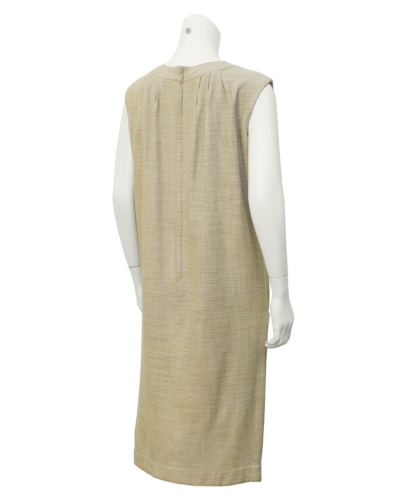 Magnifique robe Simonetta en lin beige naturel du début des années 1960. Créé avant que Simonetta ne s'associe avec Fabiani. La robe est sans manches, avec deux poches droites à l'avant et des boutons en faux cuir à l'encolure et au bas de la robe.