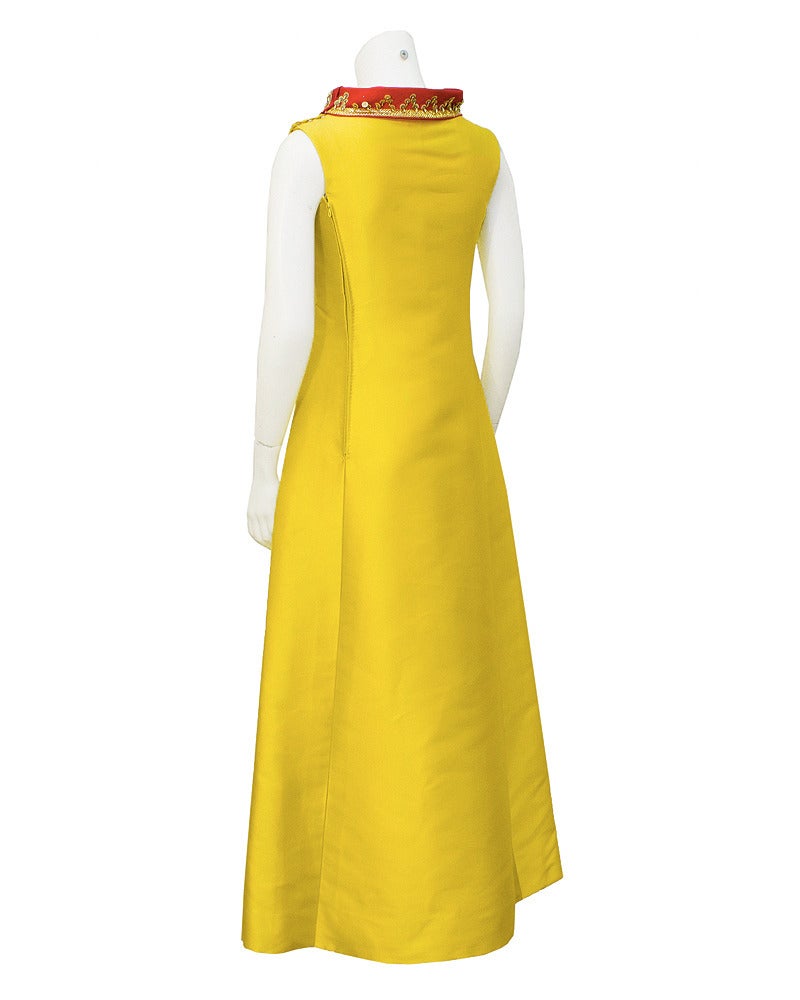 Strikingly beautiful yellow silk Lanvin gown from approximately 1967. Gown features a high mandarin like collar in a raspberry red. The two saturated colors compliment each other perfectly. Collar is embellished with Moroccan style gold trim and