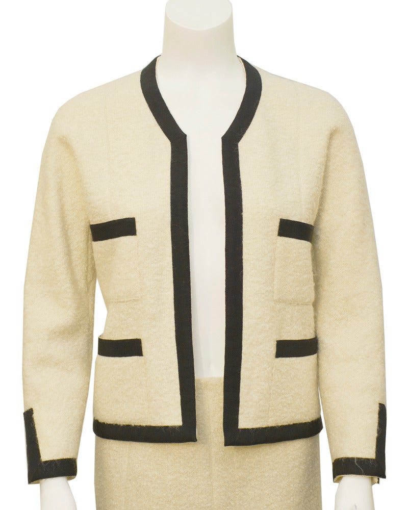 The most classic Chanel suit ever from the personal collection of Kitty D'alessio who ran Chanel in between Coco and Karl. Clean lines, white boucle and black piping on the jacket and skirt. Couture label, no buttons, in excellent condition. This