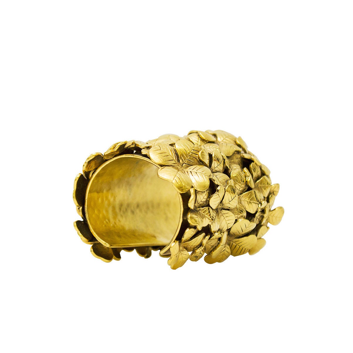 Large gold-plated Yves Saint Laurent cuff covered with clusters of detailed four leaf clovers. Opening on the back allows you to easily slide the cuff on and off. Opening can be slightly widened or tightened to fit your wrist. YSL markings stamped