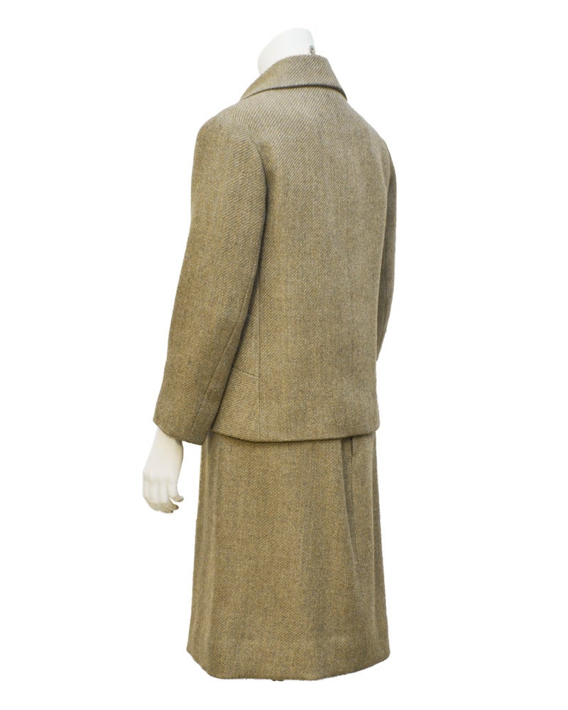 A very classic yet uniquely styled Carven suit from the 1960s. The heathered tan wool jacket features 3 slit top front pockets on both sides and tan leather knots down the front. The jacket closes with hidden hook and eye under the overlapping front