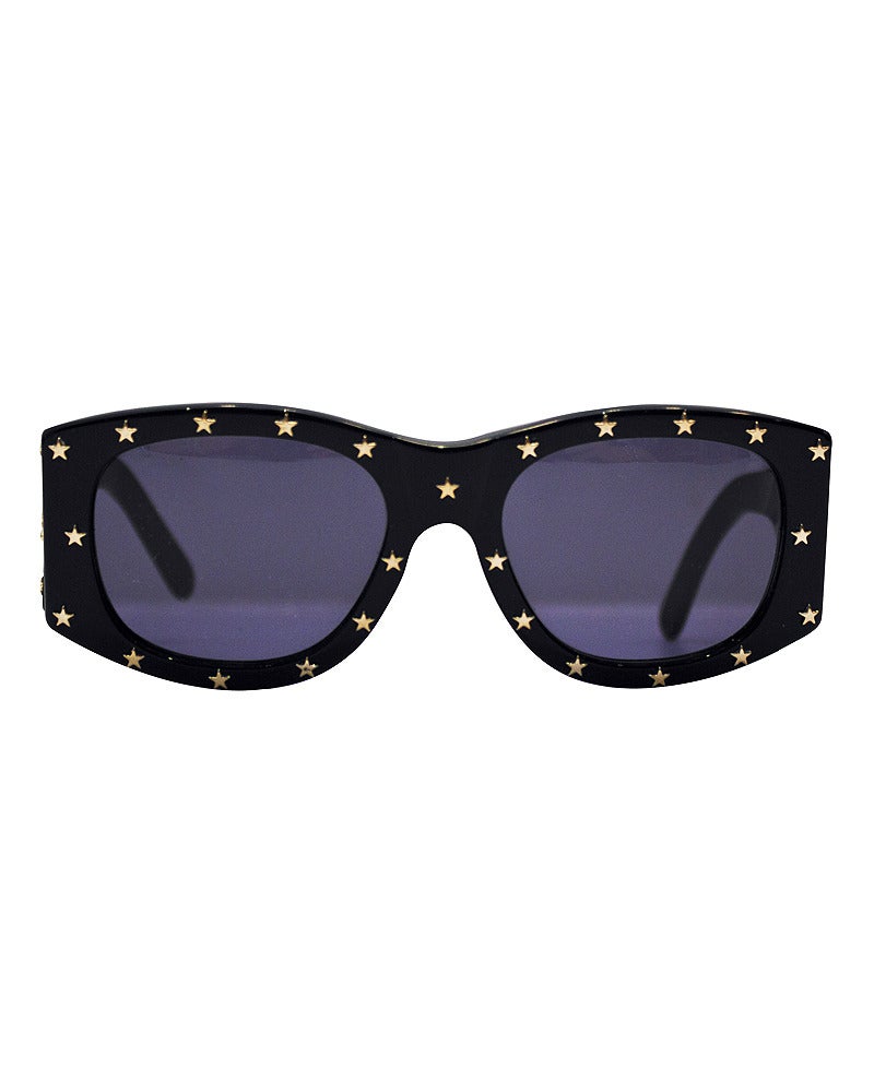 1990s black Chanel sunglasses with gold tone stars studded on the outside of frames. Large CC Chanel marking exterior of both arms. Lenses have a blue tint. Sold with original Chanel case and lens cloth. Excellent condition, no scratches.