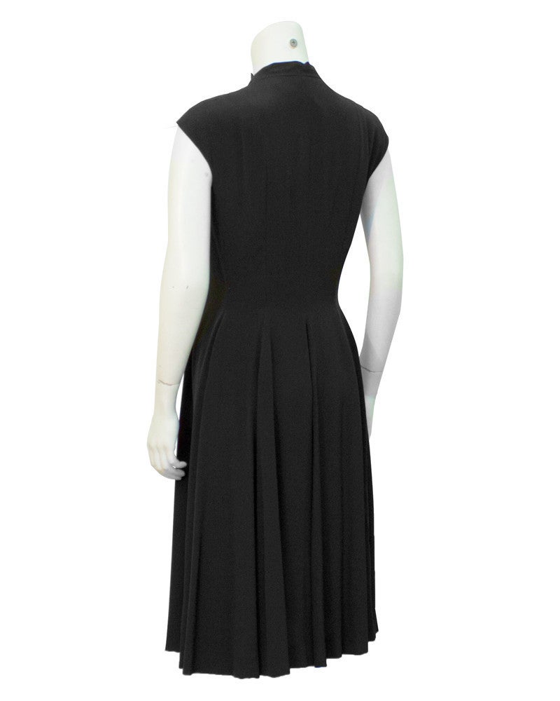 Black silk 1970's zip front cocktail/day dress with deep front V. Easy to wear with a crisp white shirt, or dress it up for evening over lacy black bra. Stitched seams along bodice for shape, full soft swing skirt. Excellent condition. Size 6.