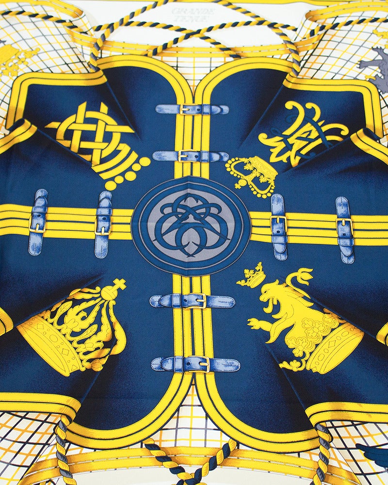 Hermes 'Grande Tenue' large silk scarf designed by Henri d'Origny. Issued in 1985 the pattern features a royal like pattern with tones of gold, red, navy blue and grey. Hand sewn rolled hems and Hermes copyright logo. Beautiful worn or framed.