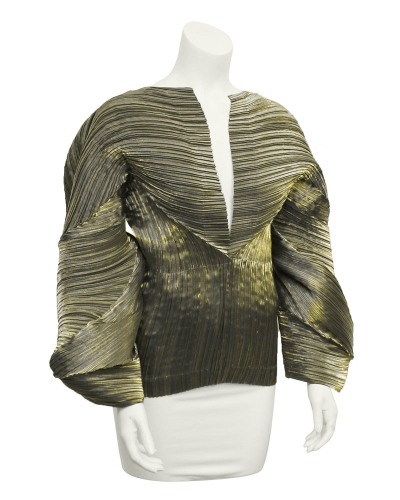 Eye catching 1990's Issey Miyake  olive with pewter undertones micro pleated polyester top. Versatile top can be styled in various ways due to its elasticity. Deep v neck and large twisted sleeves. Excellent condition. Measurements are taken when