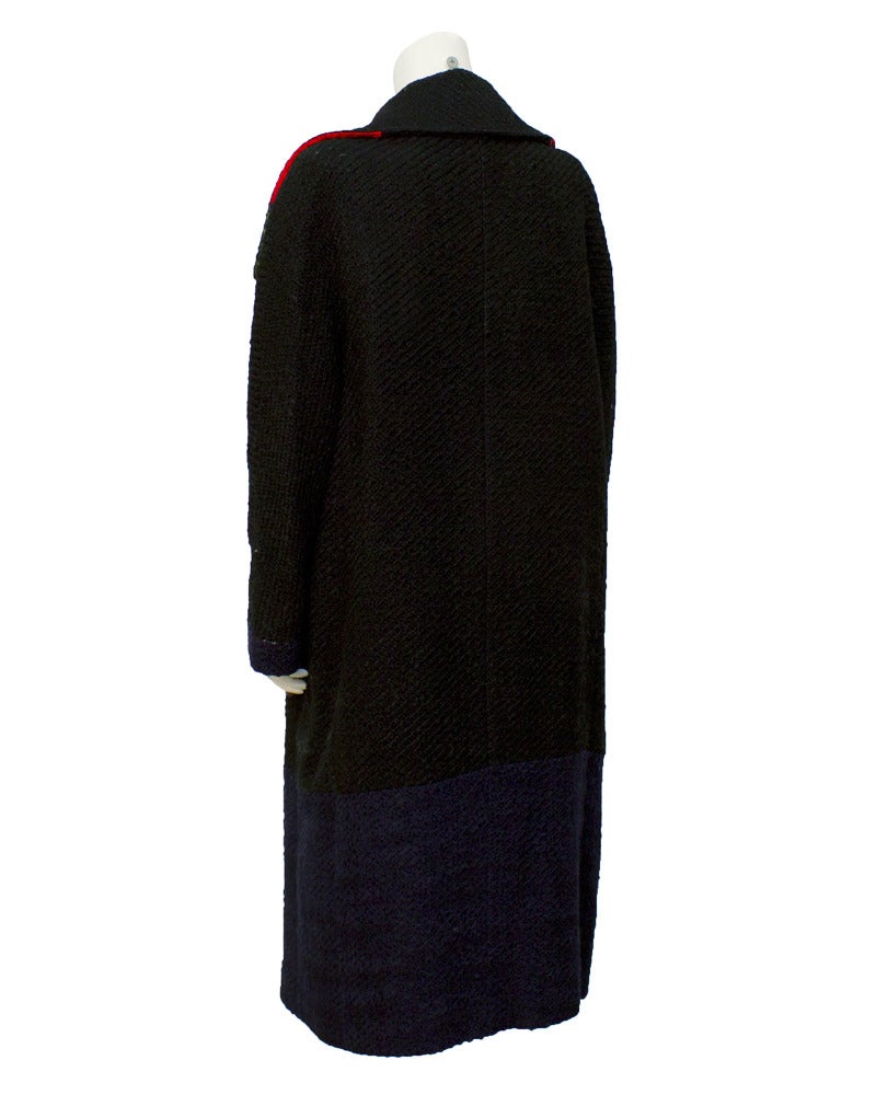 Roberta Di Camerino wool coat circa 1970's. The coat features black, red, navy blue and hunter green color blocks. Column fit, with a wide shawl collar and two side pockets. The fabric is one piece of wool over dyed in the color block patterns. A