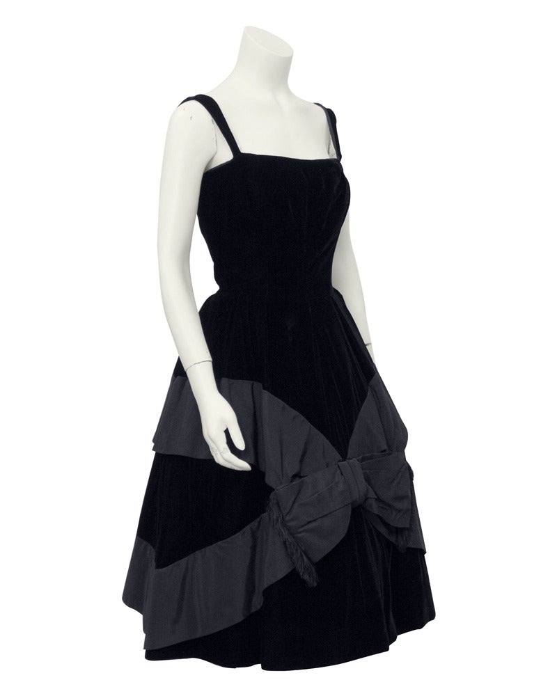 Black velvet and satin 1950’s Suzy Perette cocktail dress. The cinched waist and full A-line skirt is iconic for the Suzy Perette brand, who replicated the designs of Haute Couture houses and sold them at more attainable prices. This silhouette is