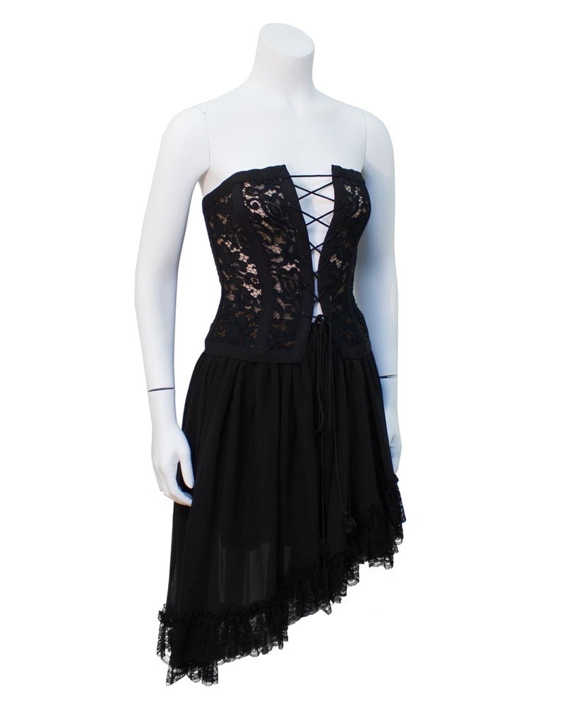 Late 1980's Saint Laurent Rive Gauche corset and skirt ensemble. Corset a has black lace overlay on top of a flesh colored lining. Corset lacing at the front is adjustable to your body. Skirt is a black silk chiffon and the bottom is trimmed with