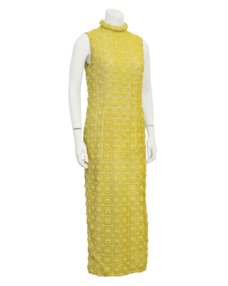 1960's gown and jacket ensemble by Marty Modell. Both gown and jacket have the most beautiful and delicate hand crochet fabric with white and yellow beading for detail over a cream colored lining. Gown is sleeveless with a high rolled collar. Jacket