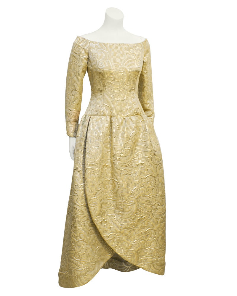 Regal 1980's Arnold Scaasi gold brocade gown. Off the shoulder, drop waist, with a tulip hem. This gown is a symbol of Arnold Scassi's craftsmanship as well as panache. In excellent, unworn condition, though missing label. Bought at an auction of